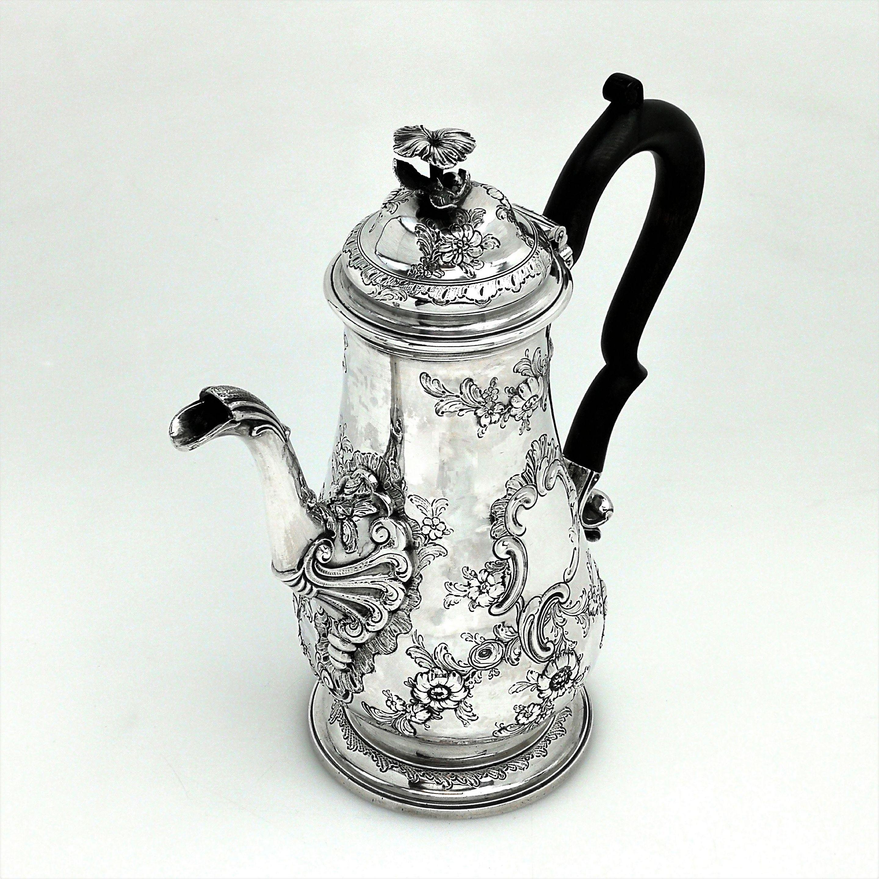 A magnificent antique George III solid silver coffee pot. This coffee pot features a beautiful chased floral and scroll design. The coffee pot stands on a spread foot and has a dark wood handle.
 
 Made in London in 1760 by John Bayley.
 
