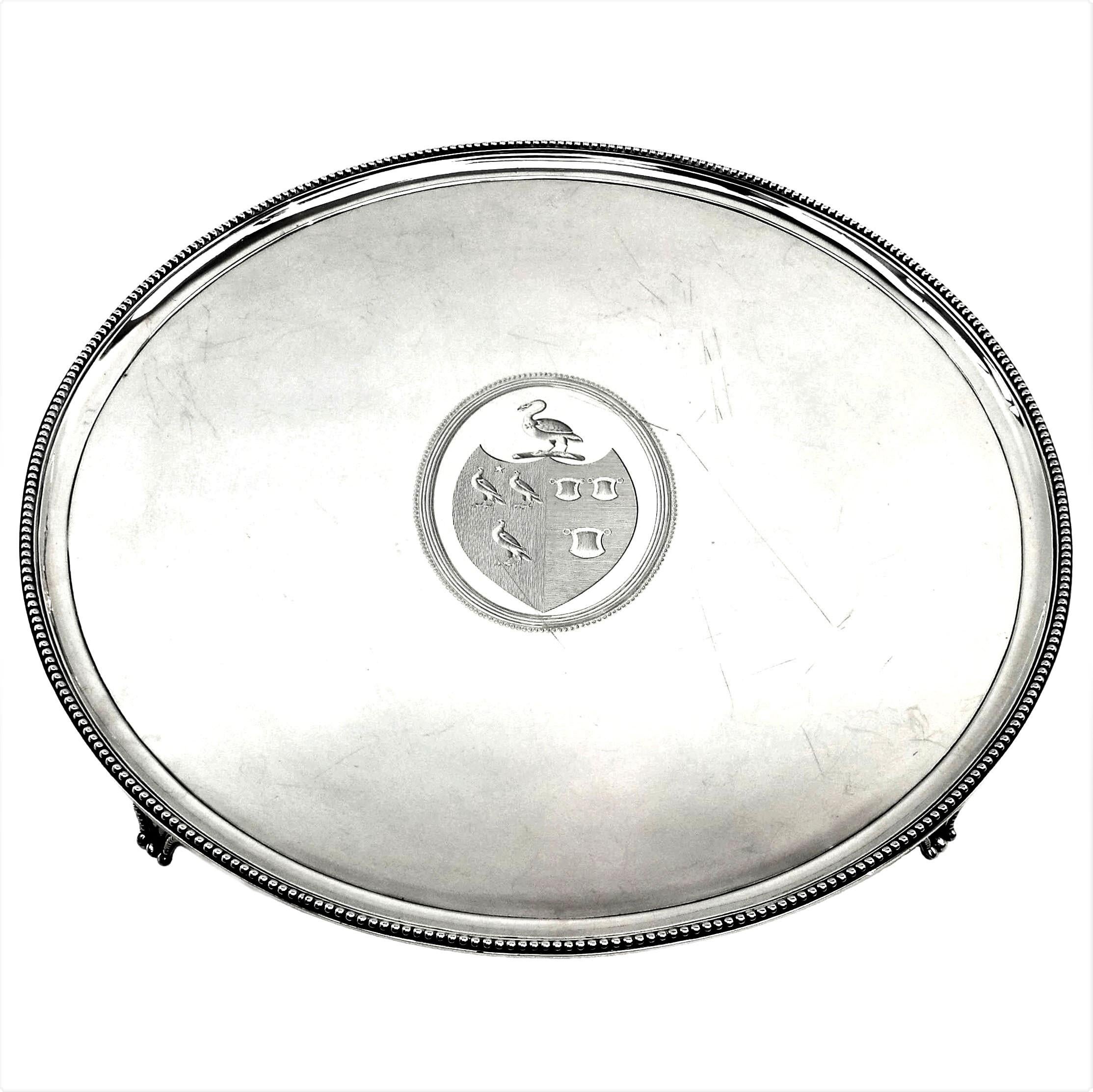 A good size Antique Georgian Solid Silver Salver / Tray standing on four Feet. The Round George III Salver is embellished with a classic beaded border around the rim and on the feet. The tray has a substantial crest engraved in the centre. 
 
 Made