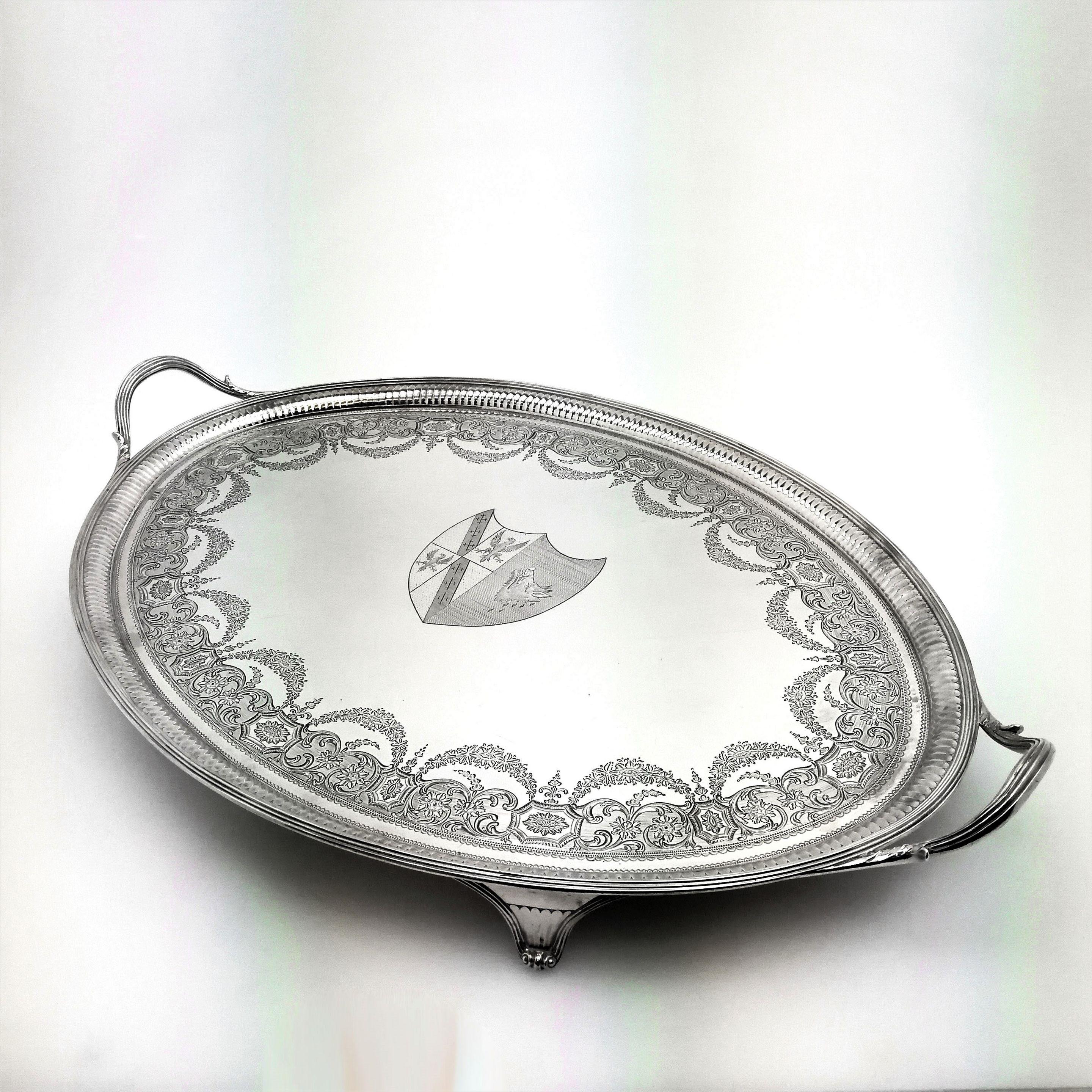 An Antique George III Georgian solid Silver Tray. This magnificent Tray has an oval shape with two handles and stands on four feet. The Tray has a reeded border on the rim and handles around a fluted band. The interior surface of the Tray has an