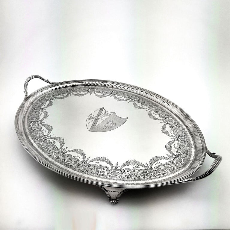 An antique George III Georgian solid Silver Tray. This magnificent Tray has an oval shape with two handles and stands on four feet. The Tray has a reeded border on the rim and handles around a fluted band. The interior surface of the Tray has an