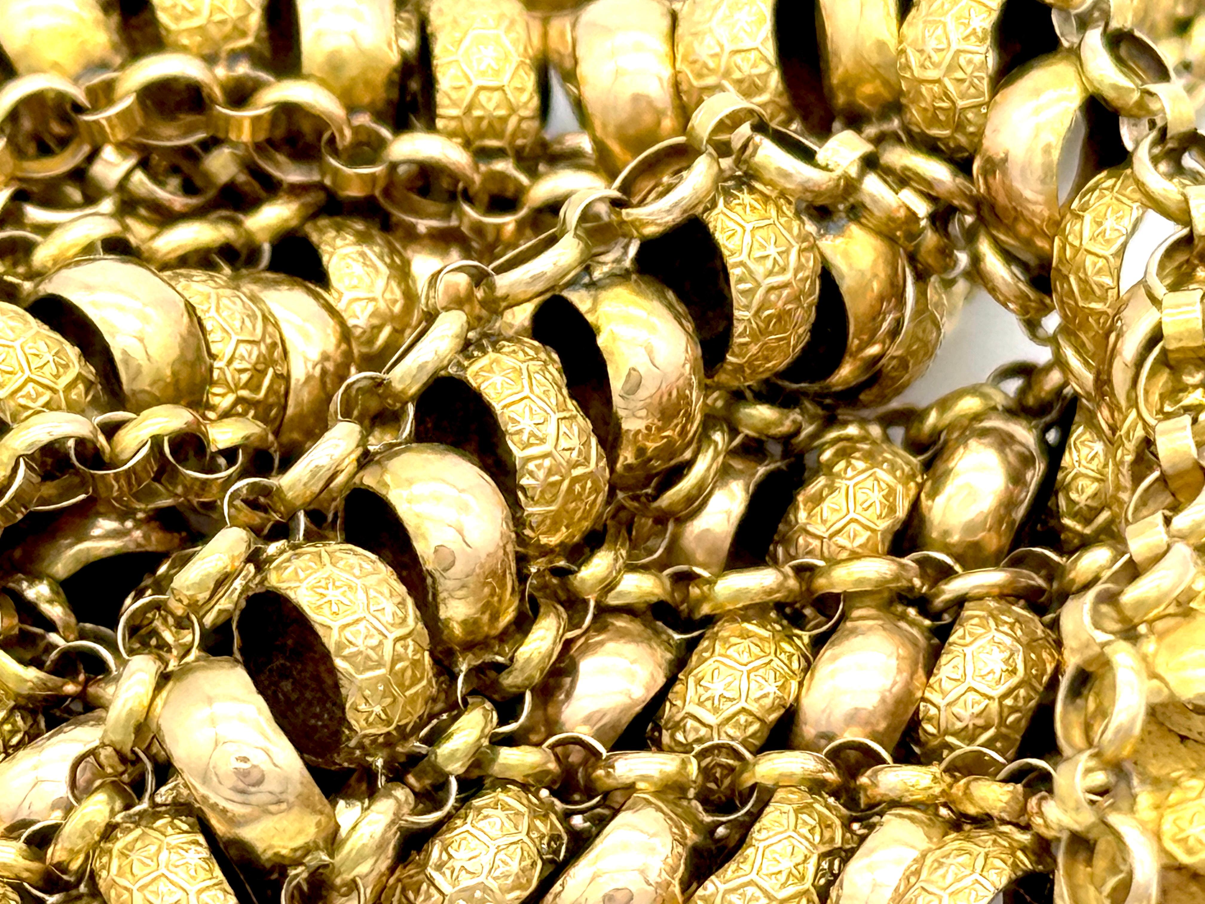 Cette élégante chaîne en or de style géorgien a été créée en 1825 environ. Elle est en or 15 carats. De larges anneaux en or avec un motif d'étoile en relief alternent avec des anneaux en or poli. Les anneaux ont de petits anneaux de chaque côté,