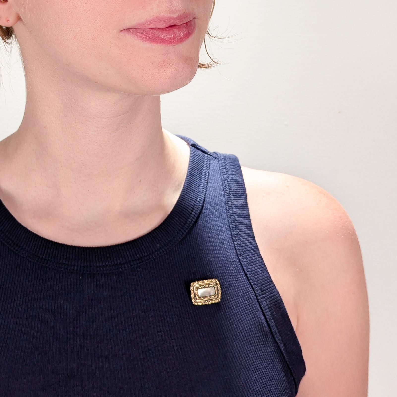 A fine antique Georgian gold, seed pearl, hair, and enamel mourning brooch.

With braided or plaited hair behind glass in a worked gold setting set with seed pearls and surrounded by a black enamel band.

The reverse bears a pin for attachment and