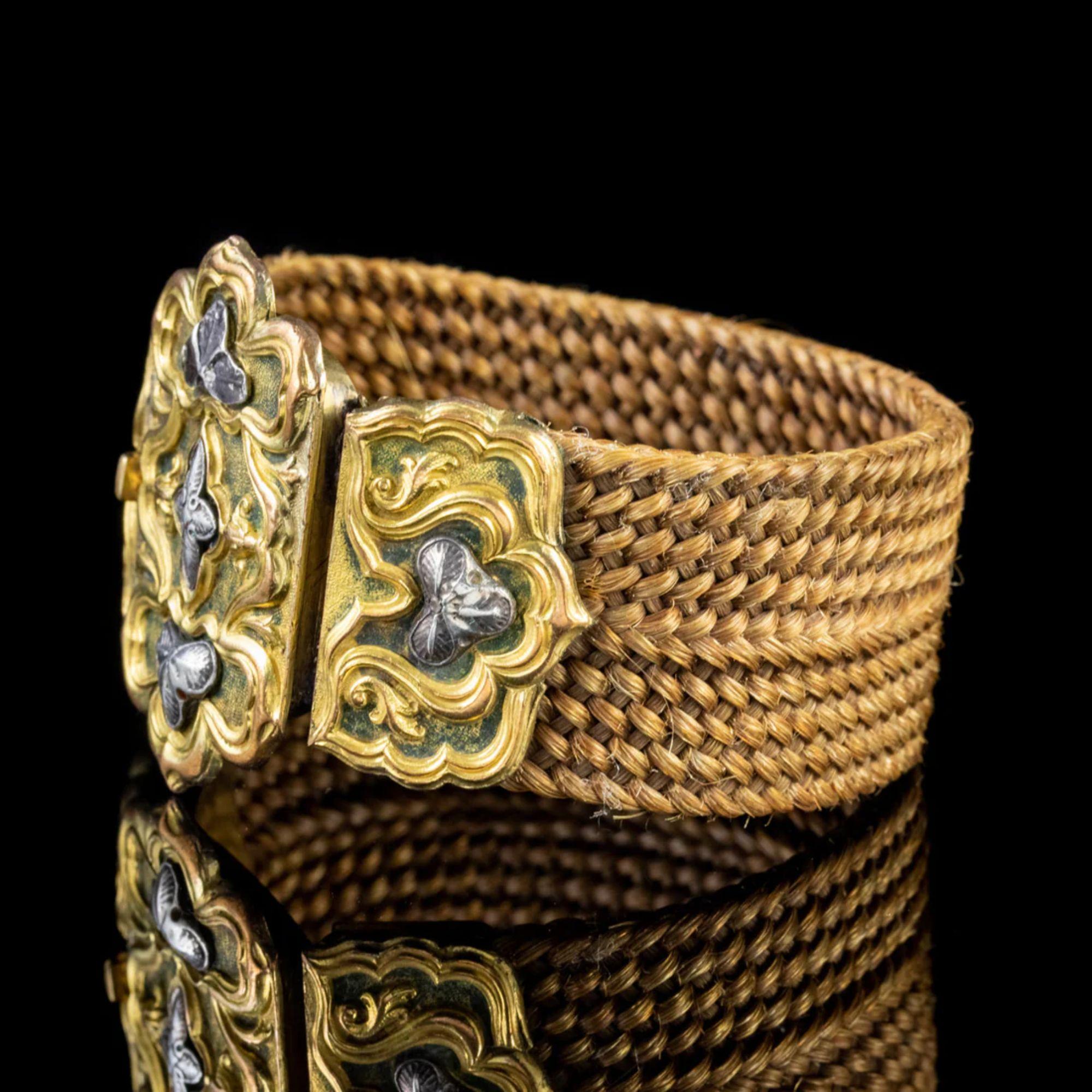 Un grand bracelet antique géorgien du début du 19e siècle composé d'une épaisse bande de cheveux tressés qui est étroitement tissée et d'une belle nuance de brun doré.

L'anneau est fixé à un grand fermoir en forme de boîte ornée d'un magnifique