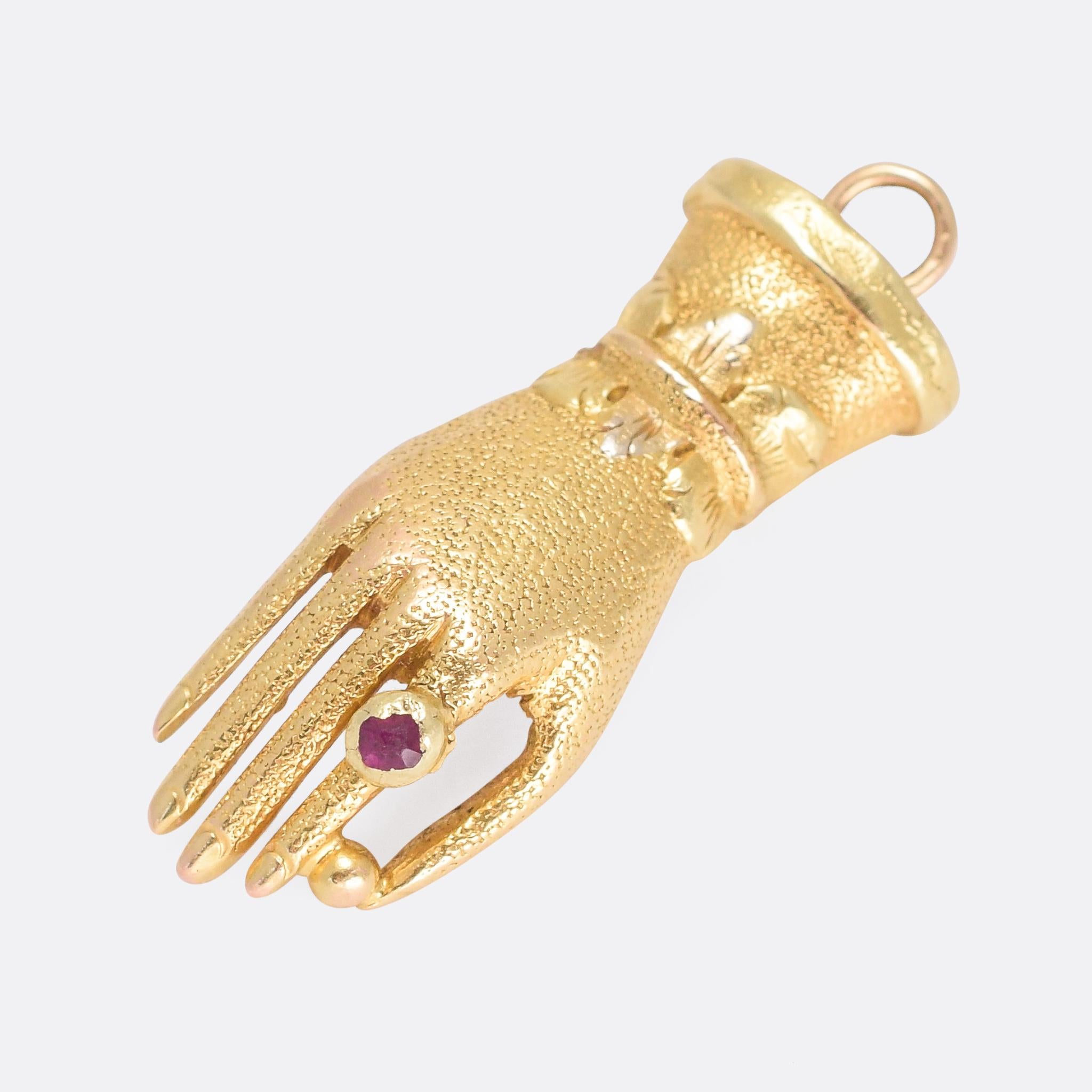 A cool Georgian hand pendant modelled in 15 karat gold and wearing a ruby ring (#jewelrywearingjewelry) The hand features an ornate collar, and holds a gold orb between the thumb and forefinger.

STONES 
Ruby

MEASUREMENTS 
2.8 x 1.0cm

WEIGHT