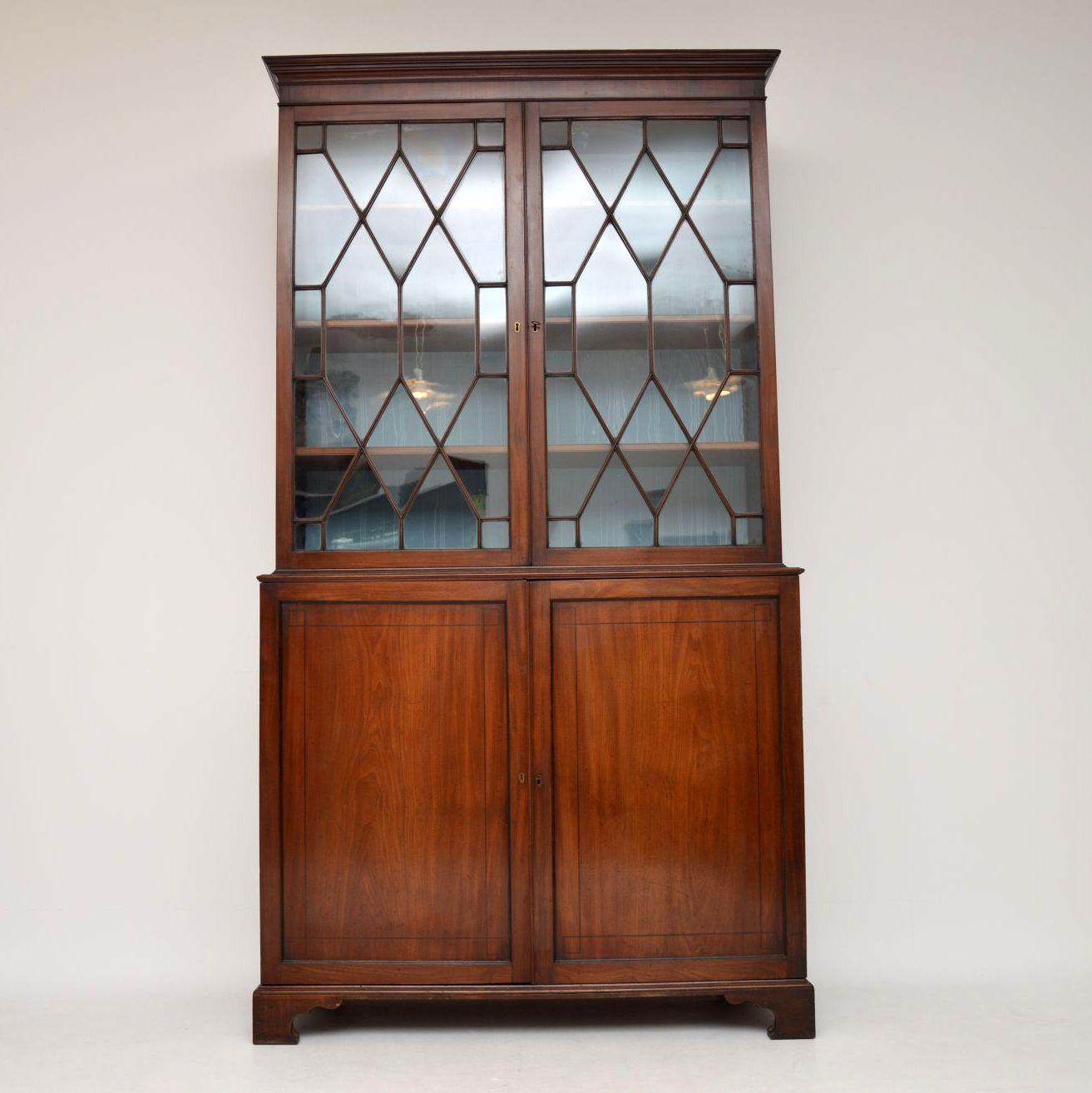 Antique George III mahogany library bookcase in two sections and in very good original condition. The astral-glazed top section has three bookshelves inside that are fully adjustable & slide in & out on fixed grooves. The back is all original and is