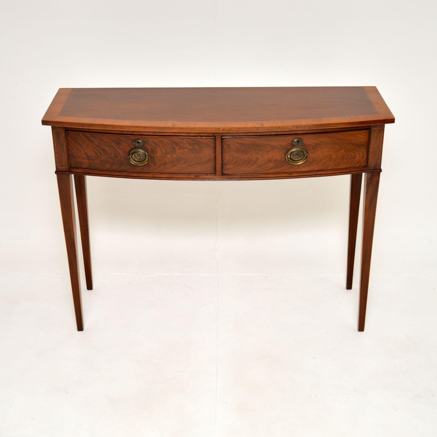 A superb antique Georgian inlaid console table. This was made in England, it dates from the 1820-40’s period.

It is of amazing quality and is an impressive size. This has a bow fronted design, the two drawers are deep and generous, with fine hand