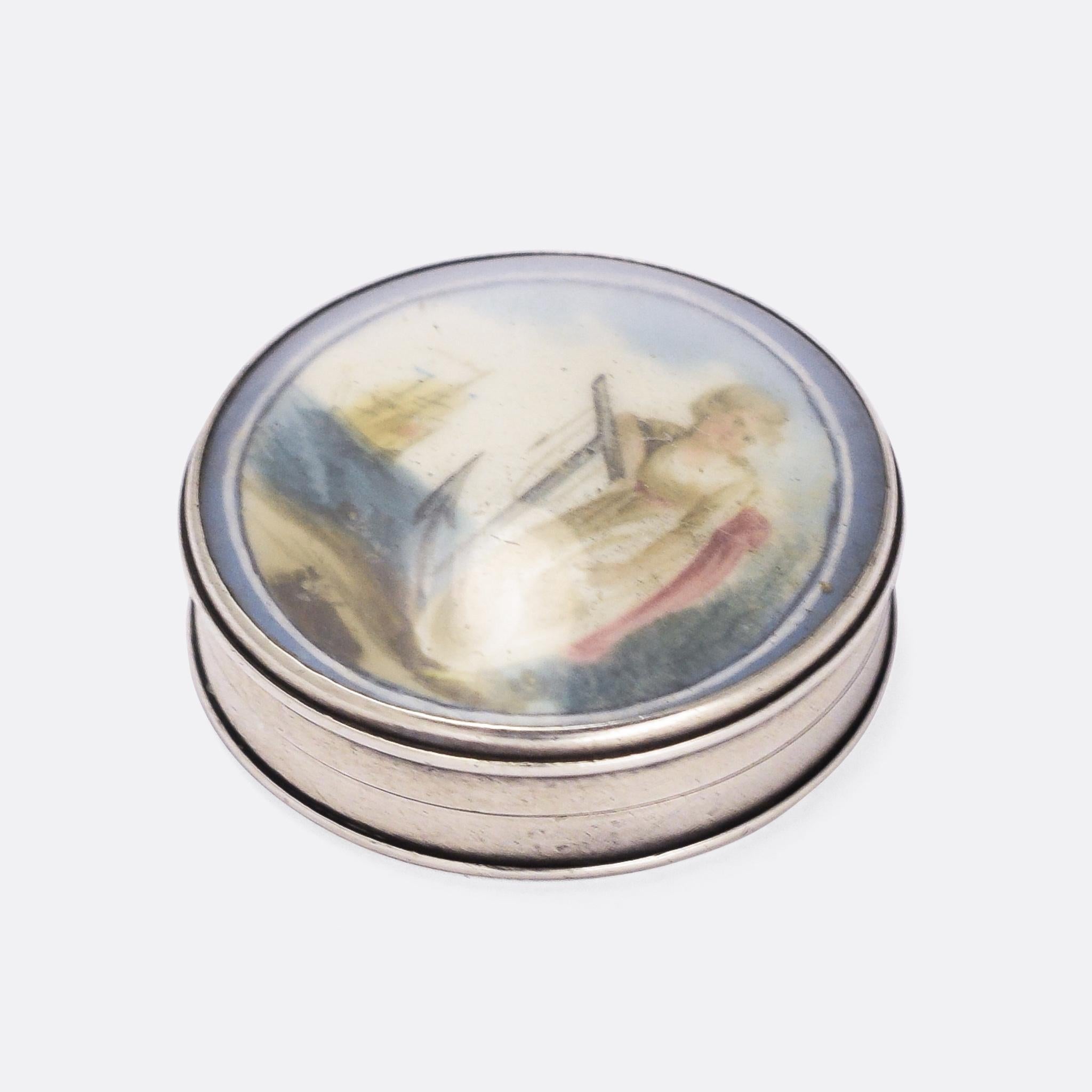 This very special little object is a patch box... dating from the late 18th Century it would have been used to store cosmetic patches, worn on the skin to cover blemishes. It's likely French origin, crafted in silver, with a beautiful miniature
