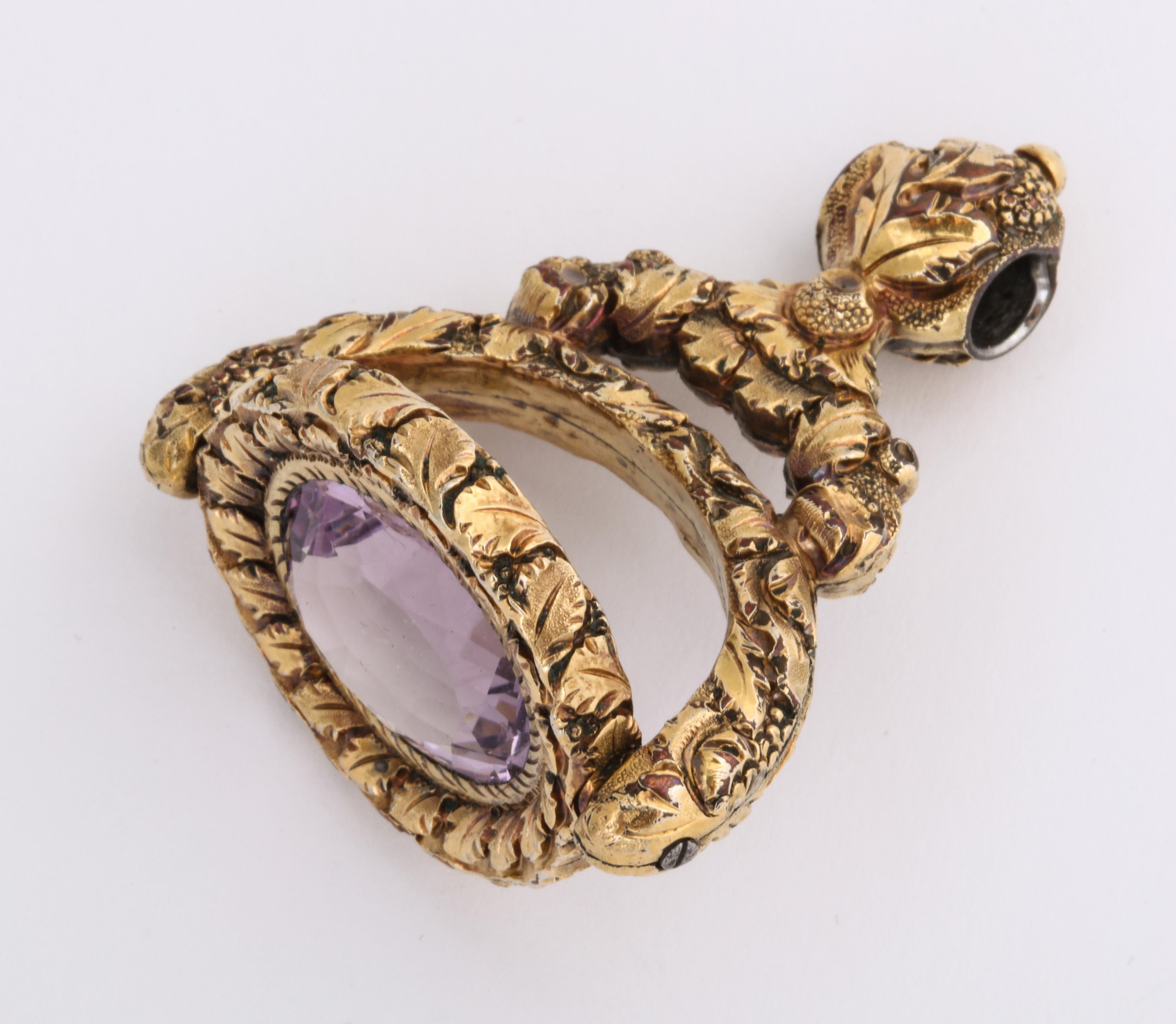 A sculptural Georgian Fob abundant with puffy engraved details of grapes and leaves that cover every surface with the exception of the huge 13 Ct amethyst at the center. The amethyst is a medium in tone chosen so as not to overpower the entire