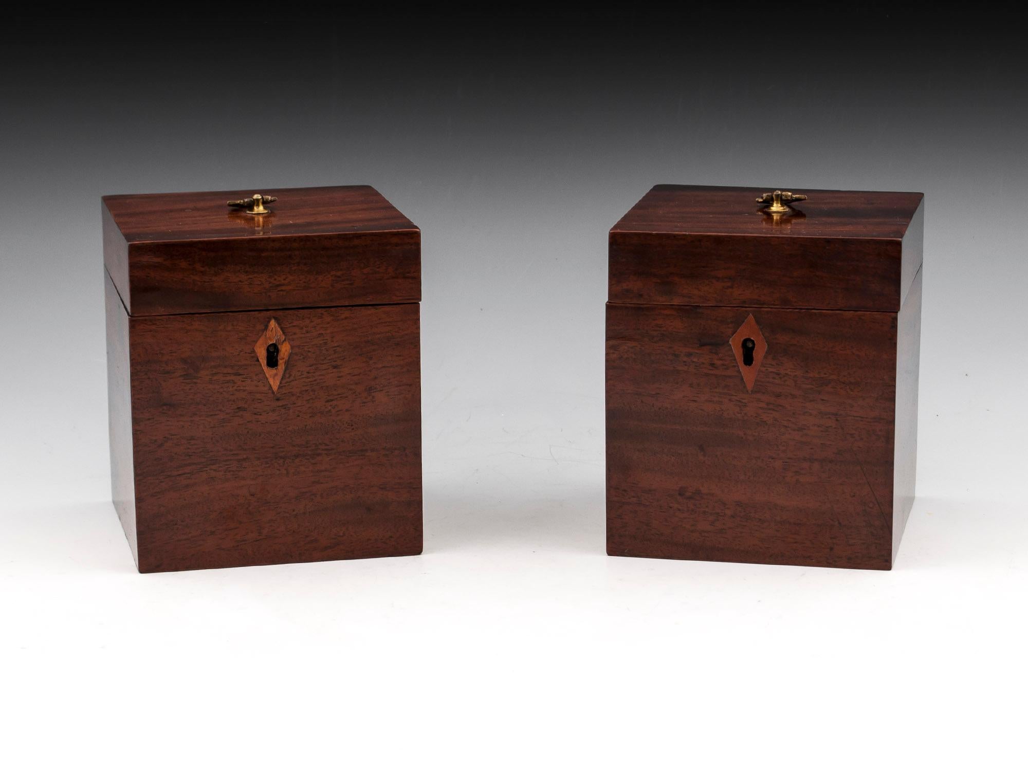 Rare pair of georgian mahogany single tea caddies with beautifully matched veneers, gilded brass handles and kite shaped escutcheons. The interiors have single lidded compartments with turned ebony handles. 
One of the cadies has a hand written