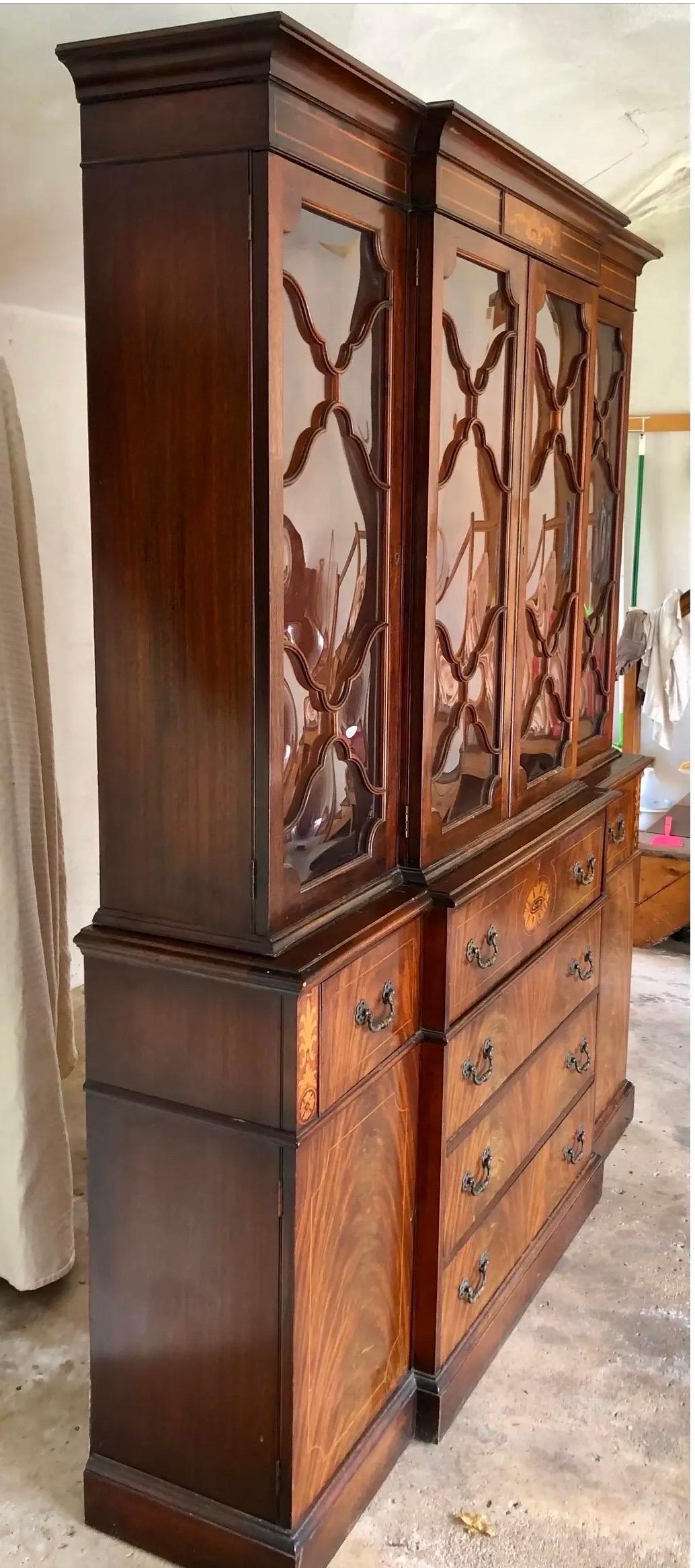 Exquisite Georgian mahogany inlay breakfront with bubble glass and built-in secretary desk option with leather top.  Comes in two pieces for ease of movement.