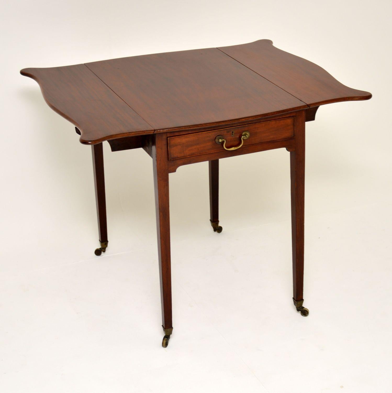 Antique George III solid mahogany Pembroke table in excellent original condition & dating to circa 1790 period.

This is a very elegant table, free from splits & warps. The drop leaves have well shaped butterfly ends & the tapered legs have brass