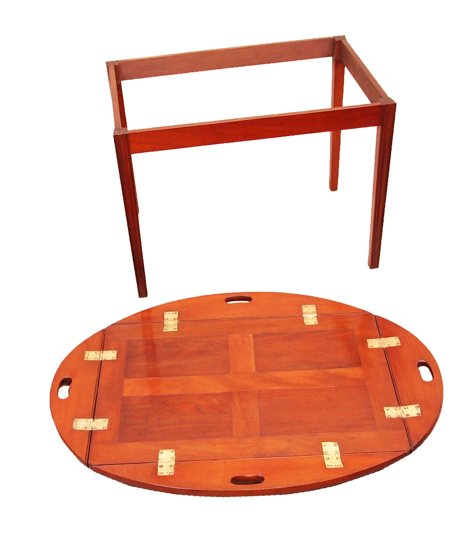 A very good quality Georgian mahogany oval
butlers tray of panelled construction having
original brass hinges to folding sides with
pierced carrying handles housed on later
mahogany square leg stand

(A great solution to the age old problem of