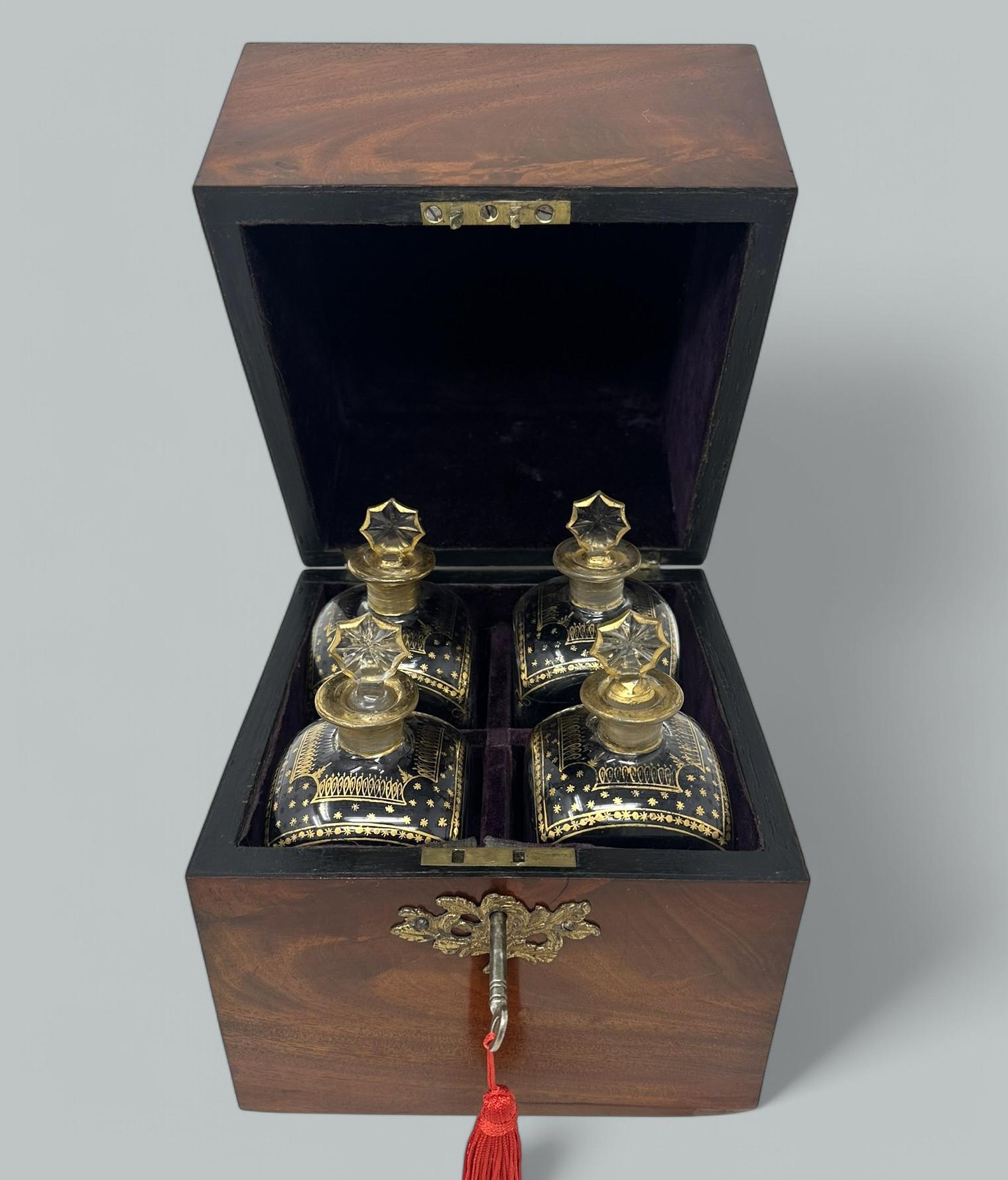 Ein außergewöhnlich schönes Beispiel für eine frühe englische George III Flame Grain Mahagoni Tantalus Box von traditioneller Form, komplett mit seinen vier ursprünglichen vergoldeten Flaschen verziert. Um 1800. 
Der Scharnierdeckel lässt sich