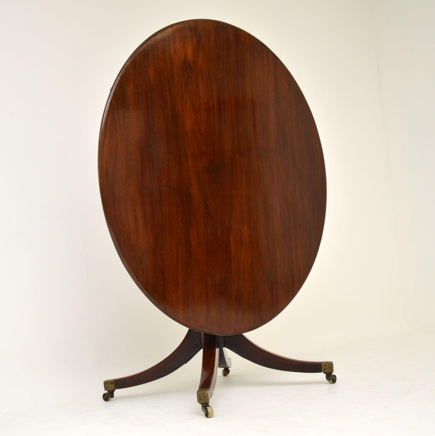 Antique Georgian solid mahogany tilt top dining table dating from circa 1810-1820 period, in good original condition and with lots of character.

I believe the brass clasp and the under bearers are all original, as are the brass capped casters.