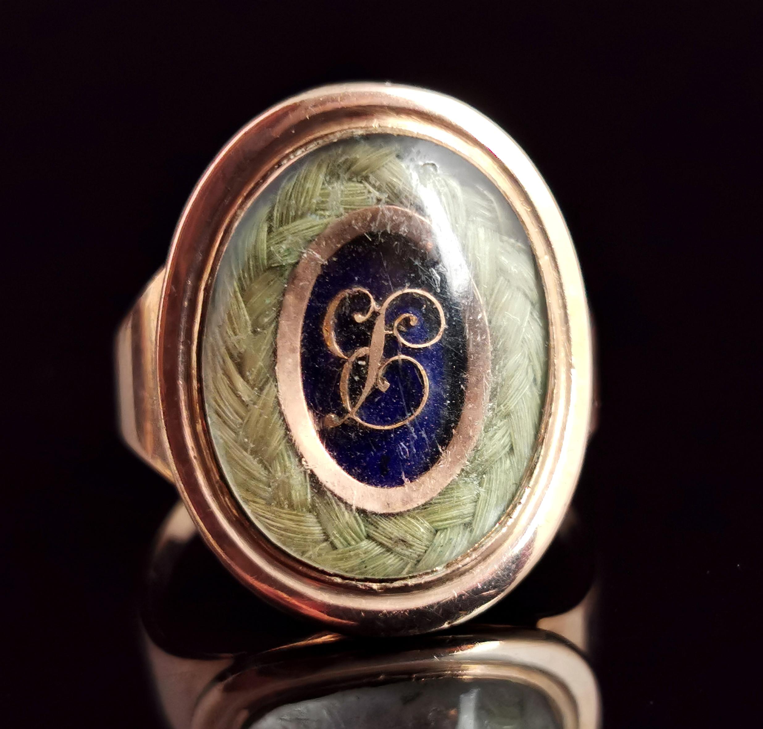 A beautiful antique Georgian era, late 18th century mourning ring.

It features a beautiful large oval face housing a lock of plaited dark blonde hair bordering a cobalt blue enamel plaque with applied rose gold lettering.

The slightly domed