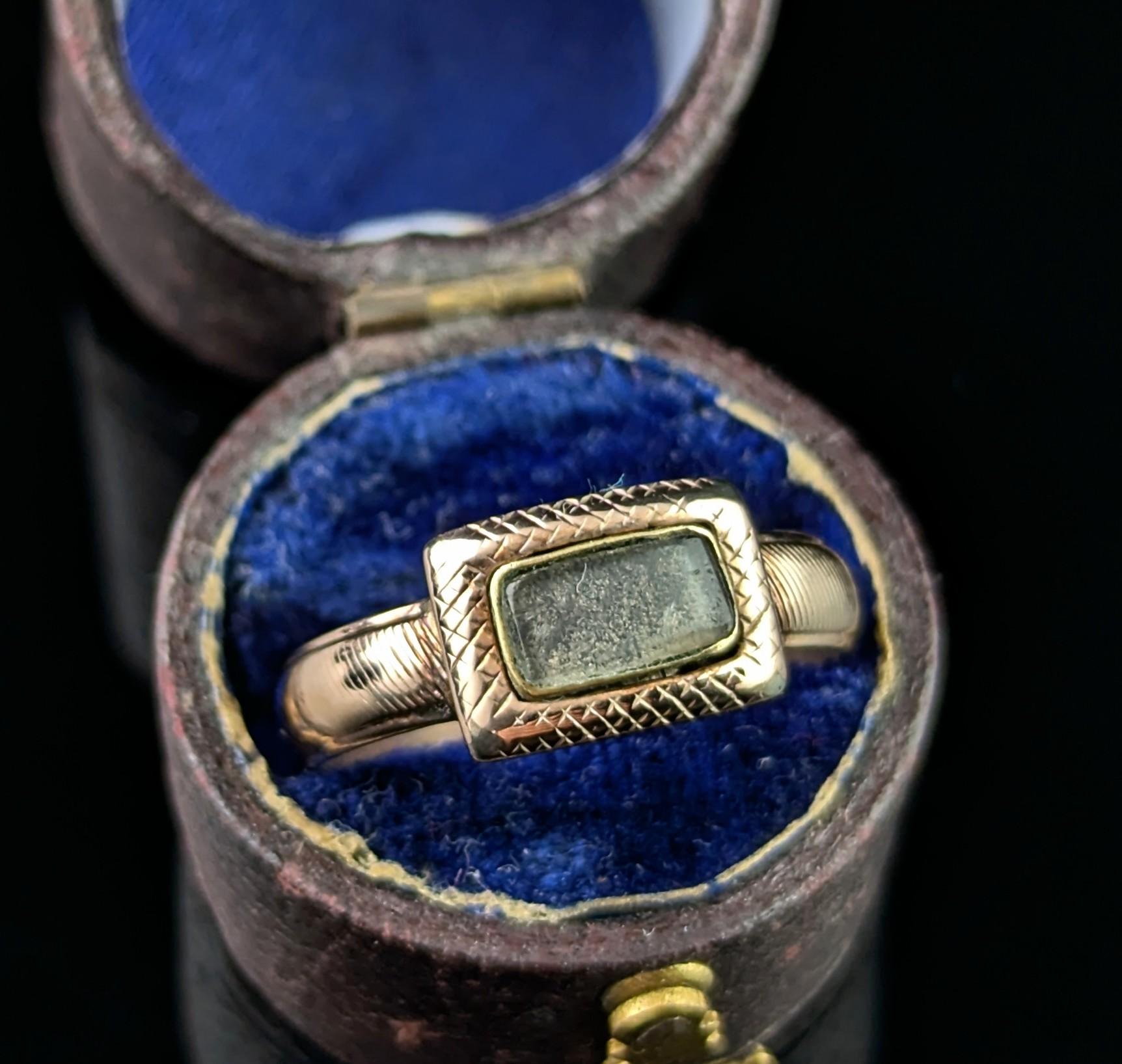 This charming antique Georgian Mourning ring is full of character.

The simple design in no way detracts from it's sentiment and beauty, an early 19th century piece it features a small glazed panel to the front enclosing a lock of hair and a