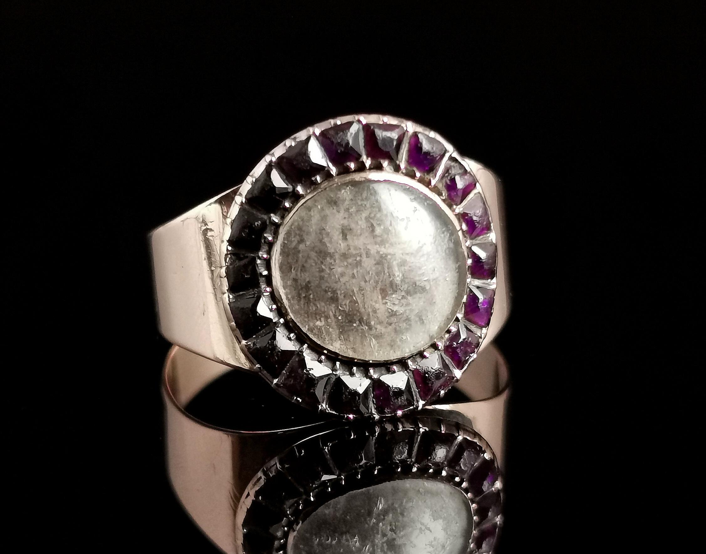 A charming antique Georgian Amethyst paste and hairwork mourning ring.

A beautiful Georgian piece in a nice design.

The face has a halo of deep purple 'Amethyst' paste stones framing the central glazed hairwork panel.

The band and shoulders are