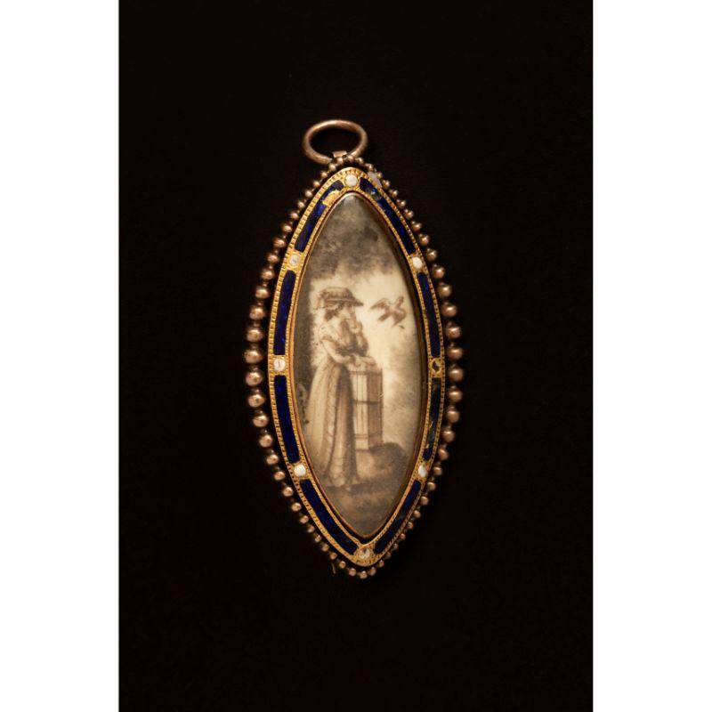 A rare antique Georgian era sepia mourning miniature in solid 9ct gold. This unique miniature comes from England and is made of solid 9ct gold adorned with blue and white enamel. The rock crystal glass preserves an undamaged miniature depicting a