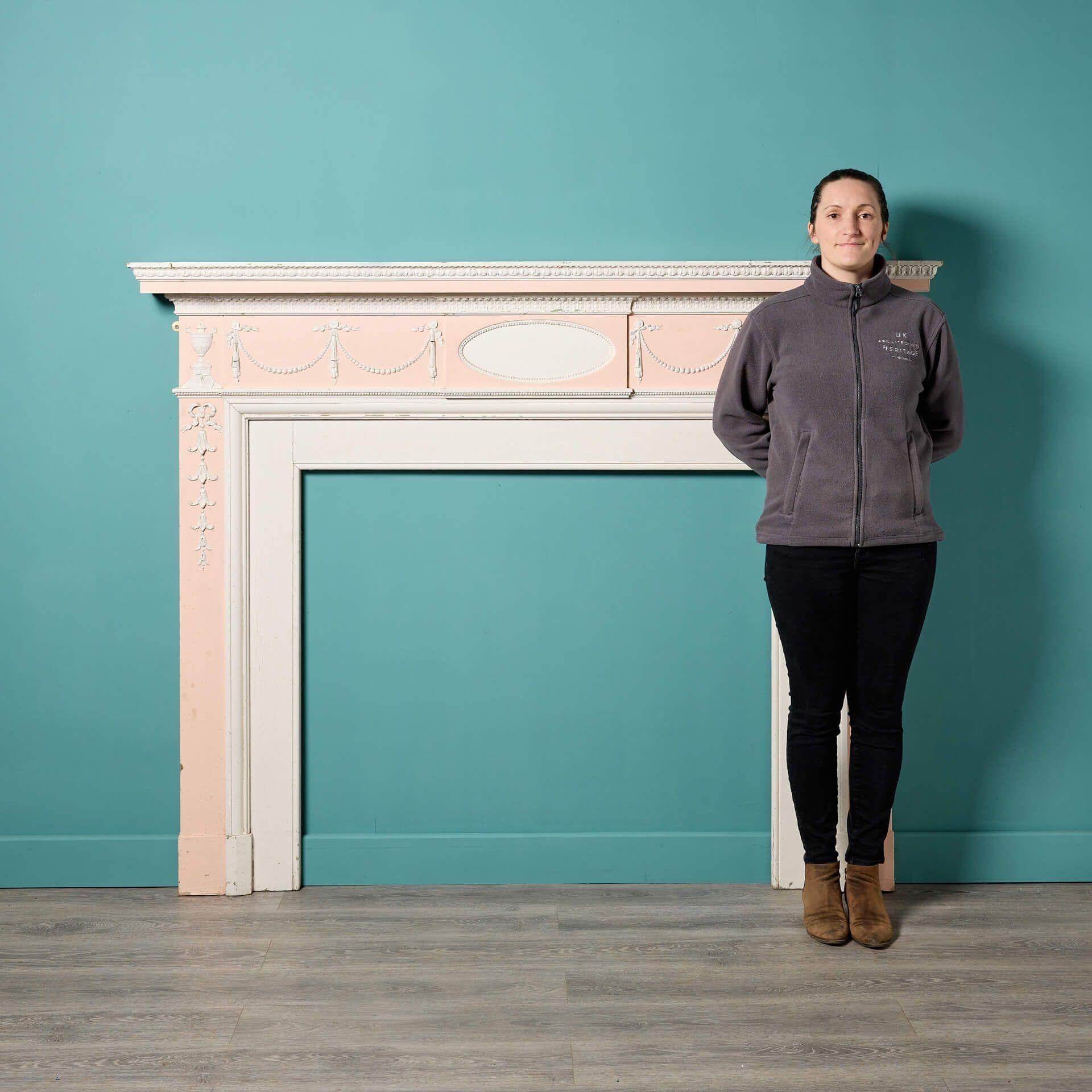 An antique Georgian Neoclassical style pine and composition fire mantel salvaged from an estate in Northamptonshire. Dating from circa 1800, this fireplace displays a beautiful design with a beautiful pale pink finish. A perfect feature for