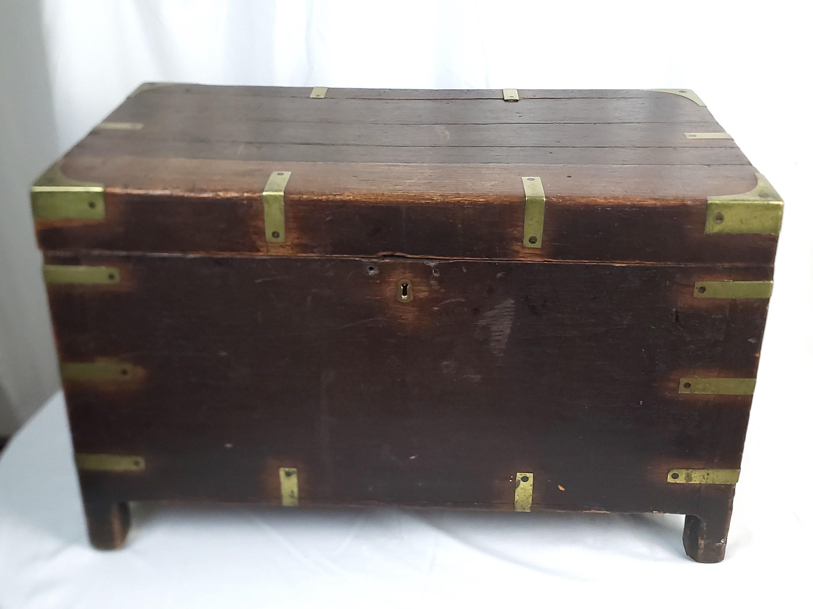This antique hand-crafted chest is unsigned, but presumed to have originated from England and date to approximately 1785 and done in the period Georgian style. The chest is composed of oak with brass accents around the top and down the sides and
