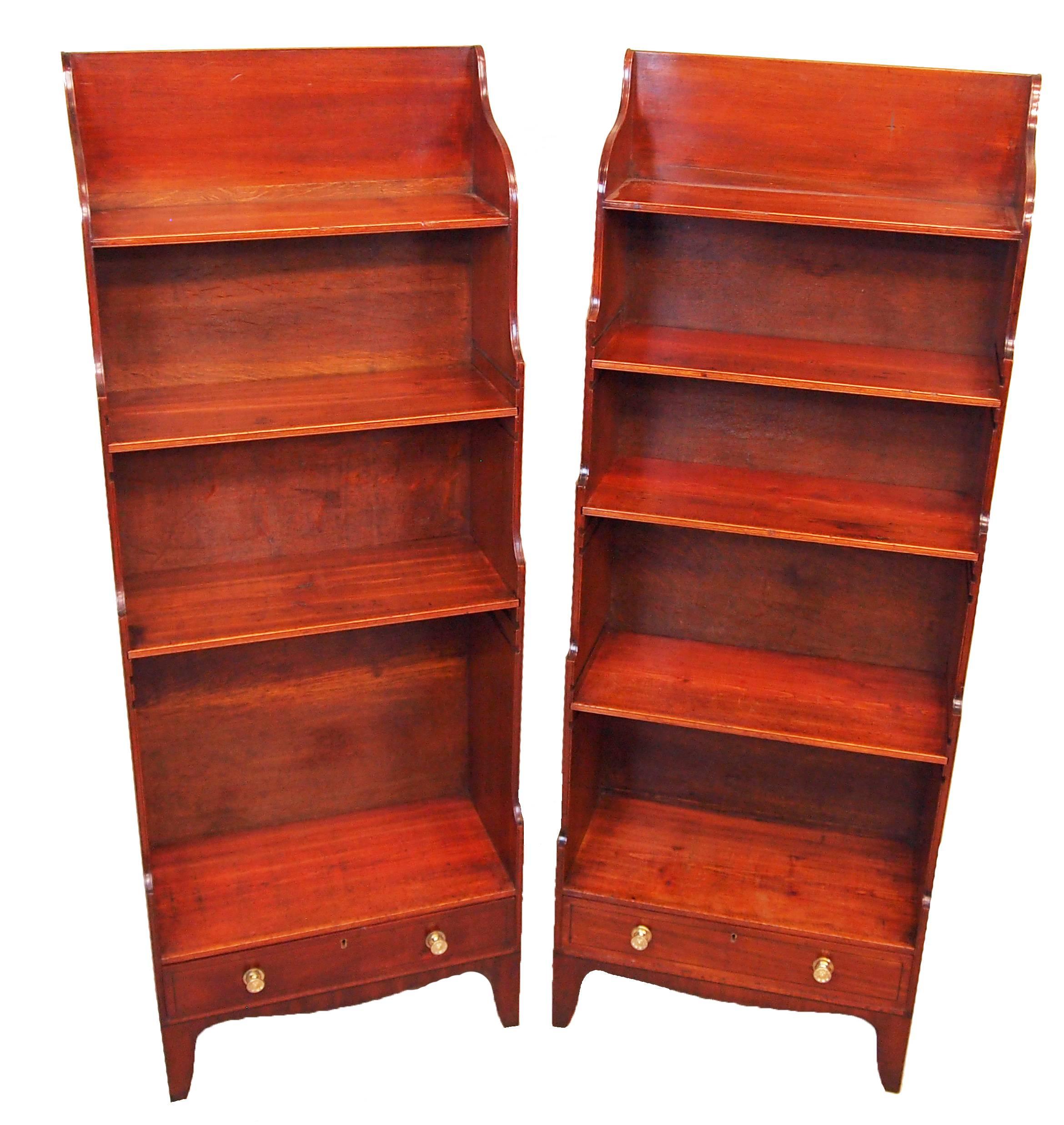 A very good quality and elegant pair of George III period
mahogany waterfall open bookcases each with differing
graduation to adjustable shelves flanked by brass carrying
handles above one frieze drawer raised on elegant
splayed feet with shaped