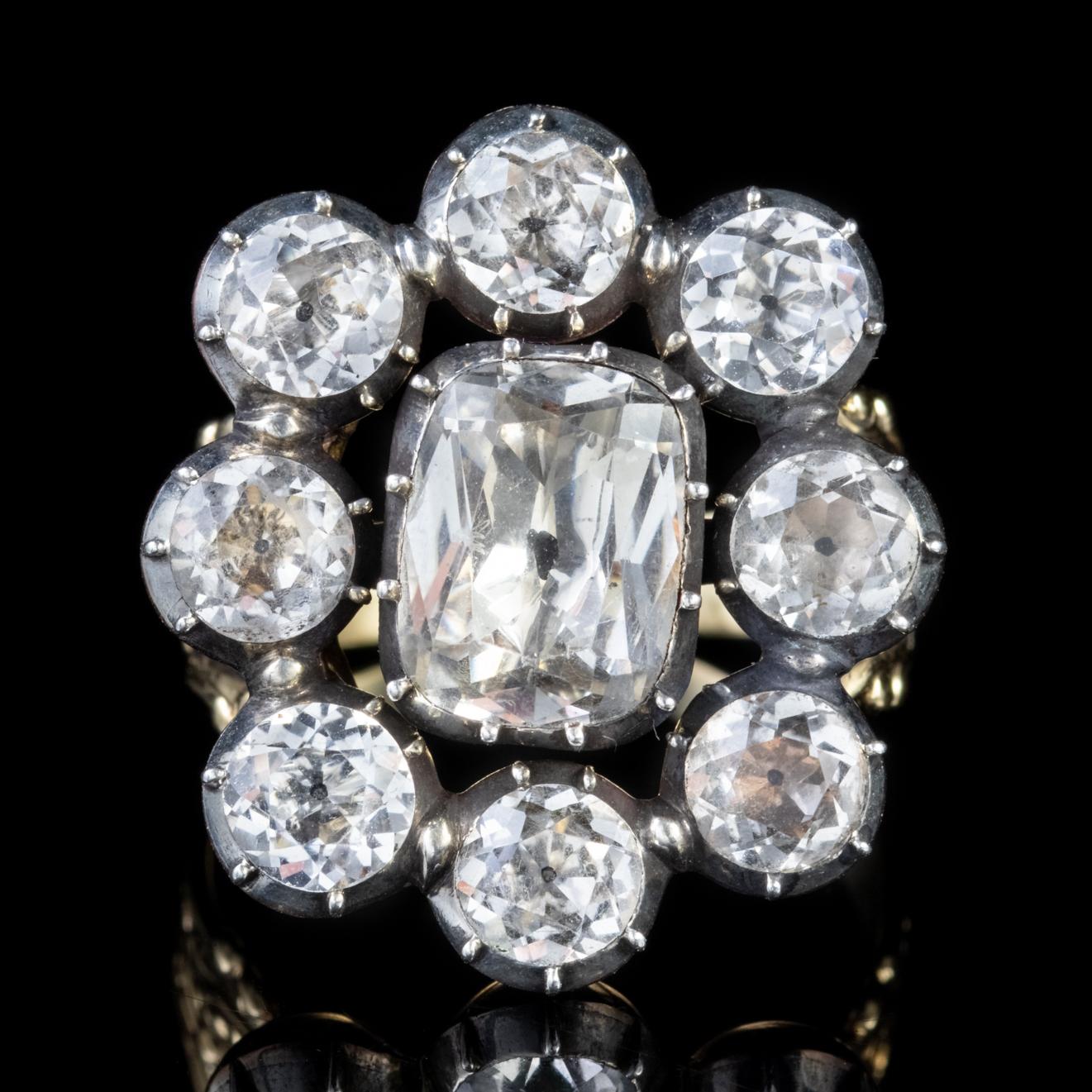 A grand antique Georgian cluster ring adorned with eight old cut white Paste Stones which are all 0.50ct and halo a larger central Paste which is approx. 2.80ct. 

Paste is a transparent flint glass that simulates the fire and brilliance of