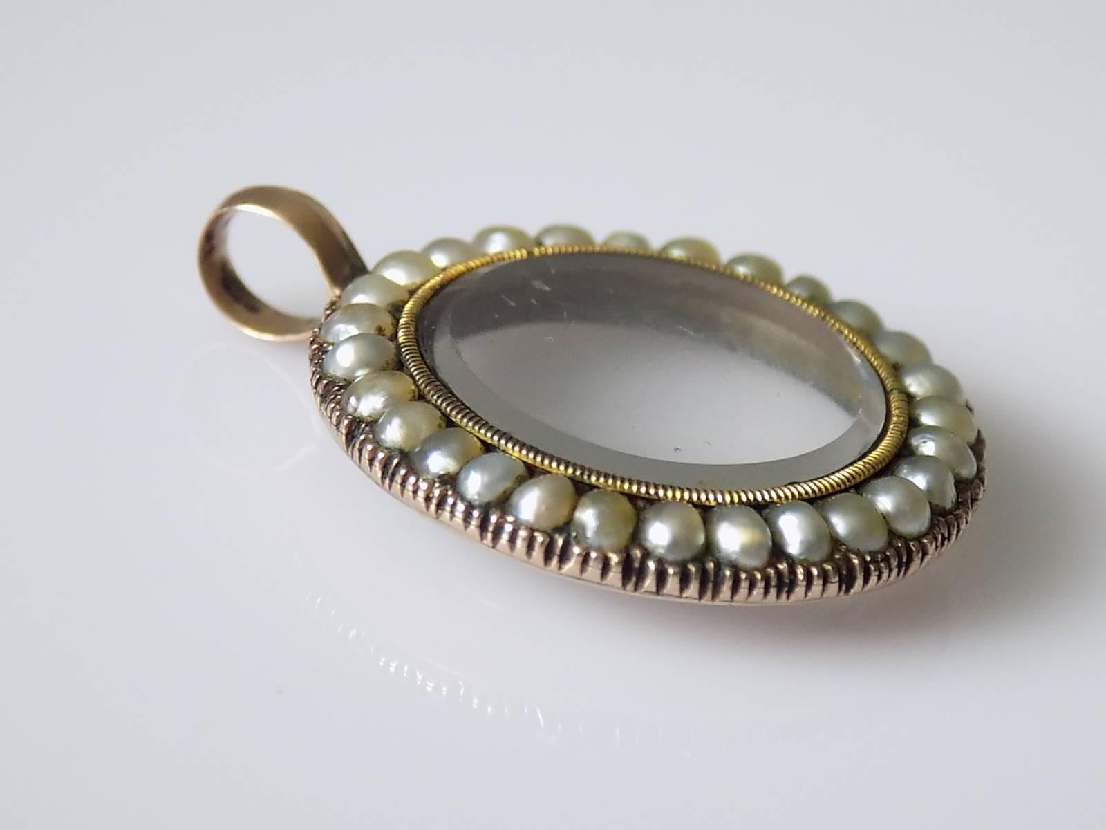 A Lovely Georgian c.1820 split Natural Seed Pearl glazed locket pendant in 9 Carat Gold. English origin.
Drop including bale 35mm
Width 27mm.
Width of glazed locket 20mm.
Unmarked, tested 9 Carat Gold.
Locket in very good working order, glass with a