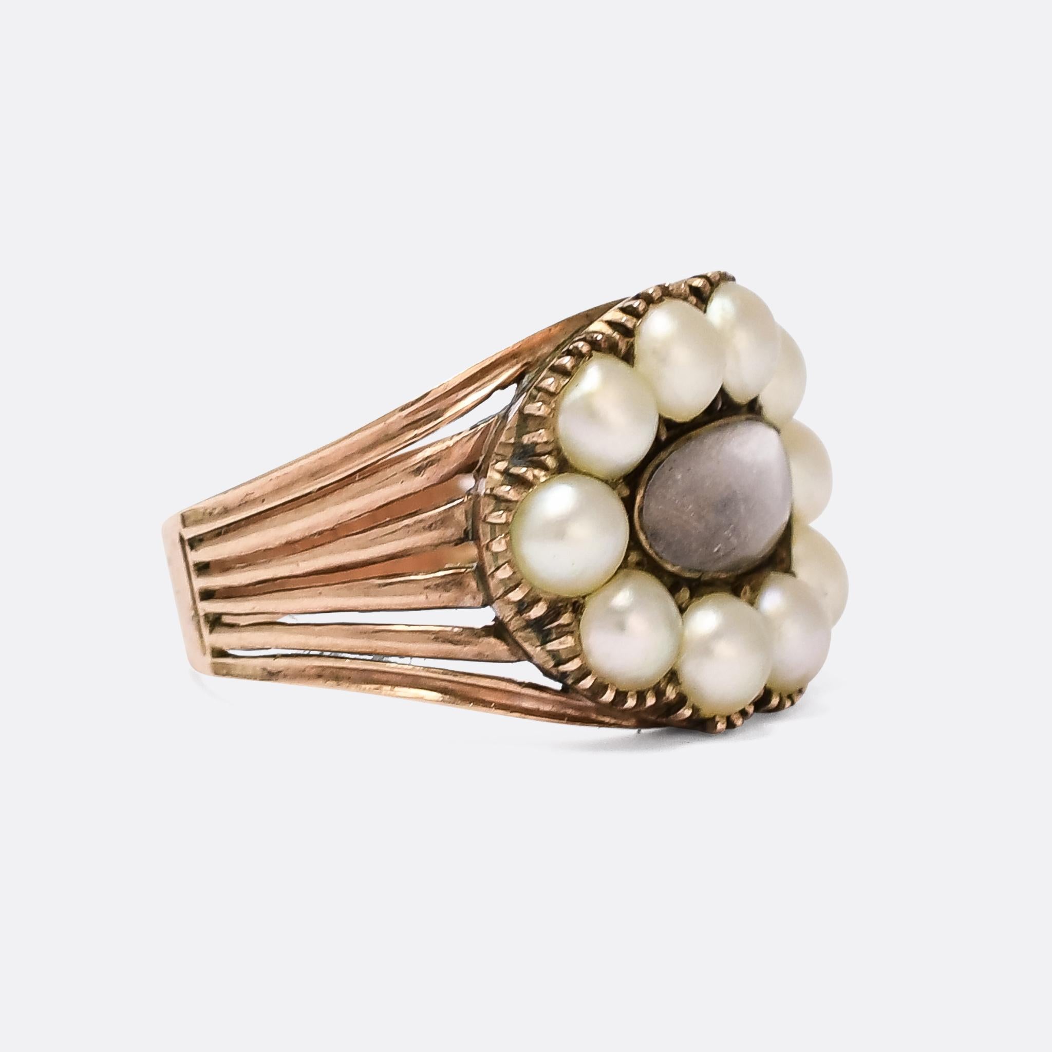 A gorgeous Georgian memorial ring dating from the early 19th Century, circa 1820. It features a finely woven locket of hair behind an oval glass compartment, within a border of natural pearls in crimped settings. The shoulders split into six