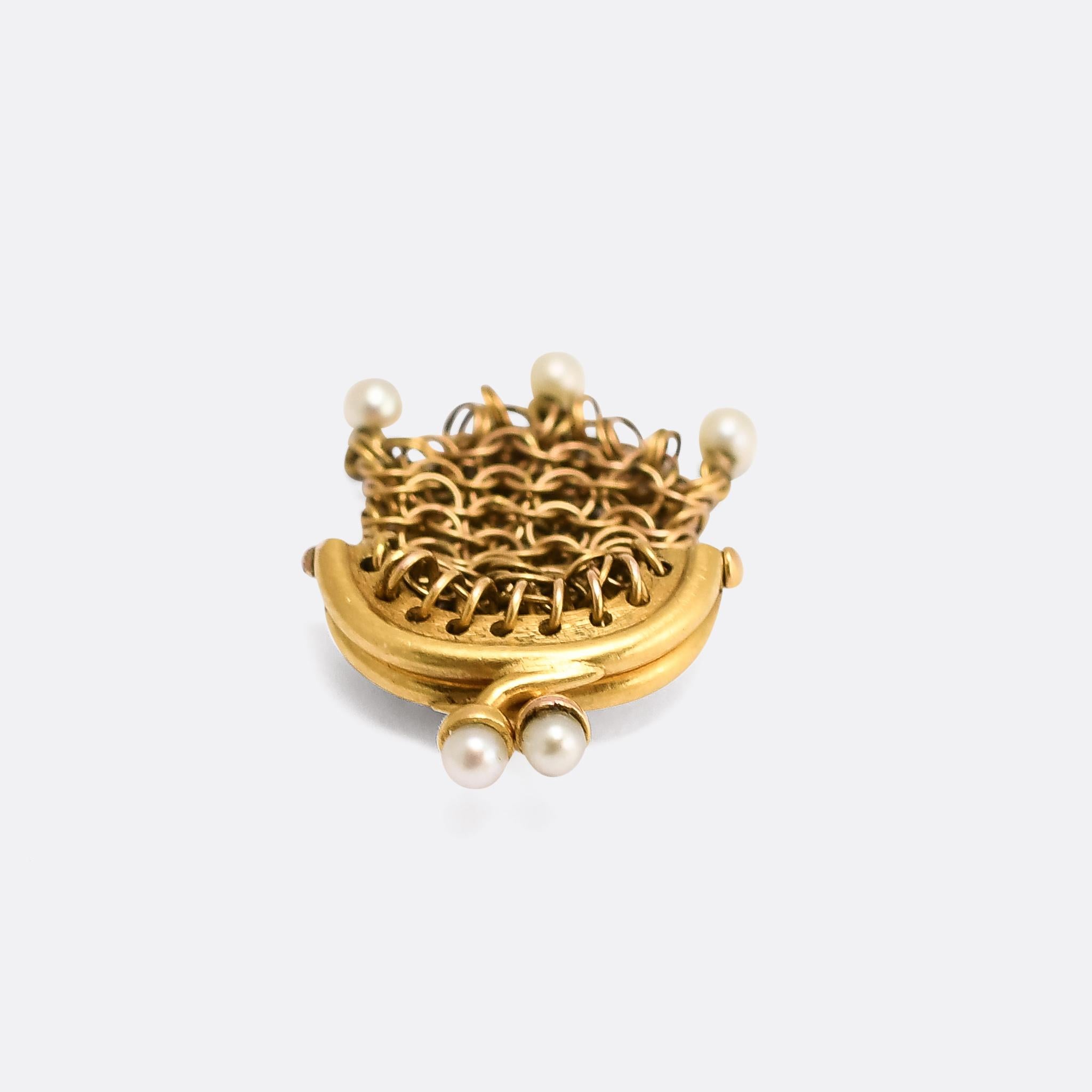 An unusual Georgian Miser's Purse charm in 18k gold. It comprises interlinked gold hoops to form the main body, with a hinged top section that opens to grant access. While there's not enough room inside for actual coins, it's a perfect size to hold