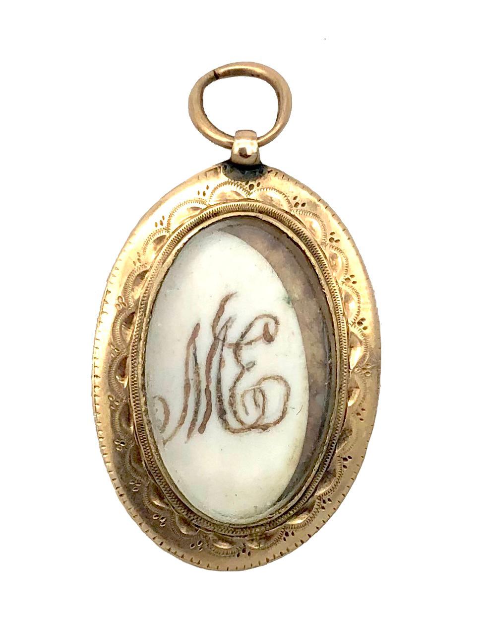 This fine quality Georgian pendant locket has been handcrafted out of 15 karat gold. Within a yellow gold double frame the front of the locket has been painted with bright red translucent enamel over a golden surface covered with an intricate