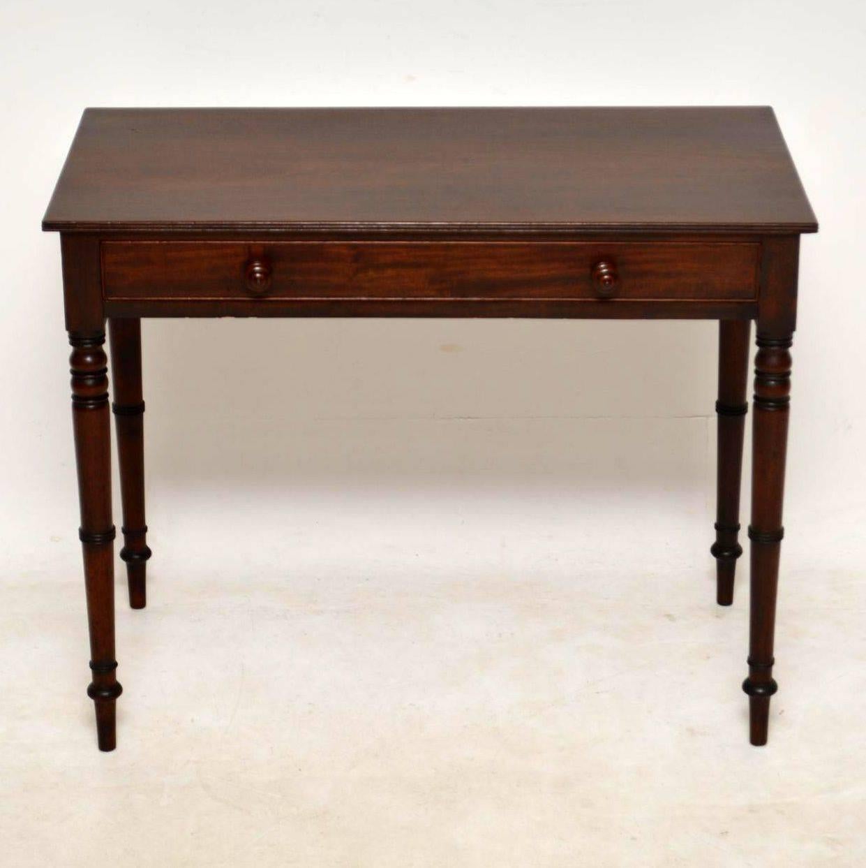 Elegant antique period Georgian writing table desk in good original condition and dating from around the 1810s-1820s period. The top is solid mahogany and has a reeded edge. There's one long drawer with a cock-beading edge, fine dovetails and turned