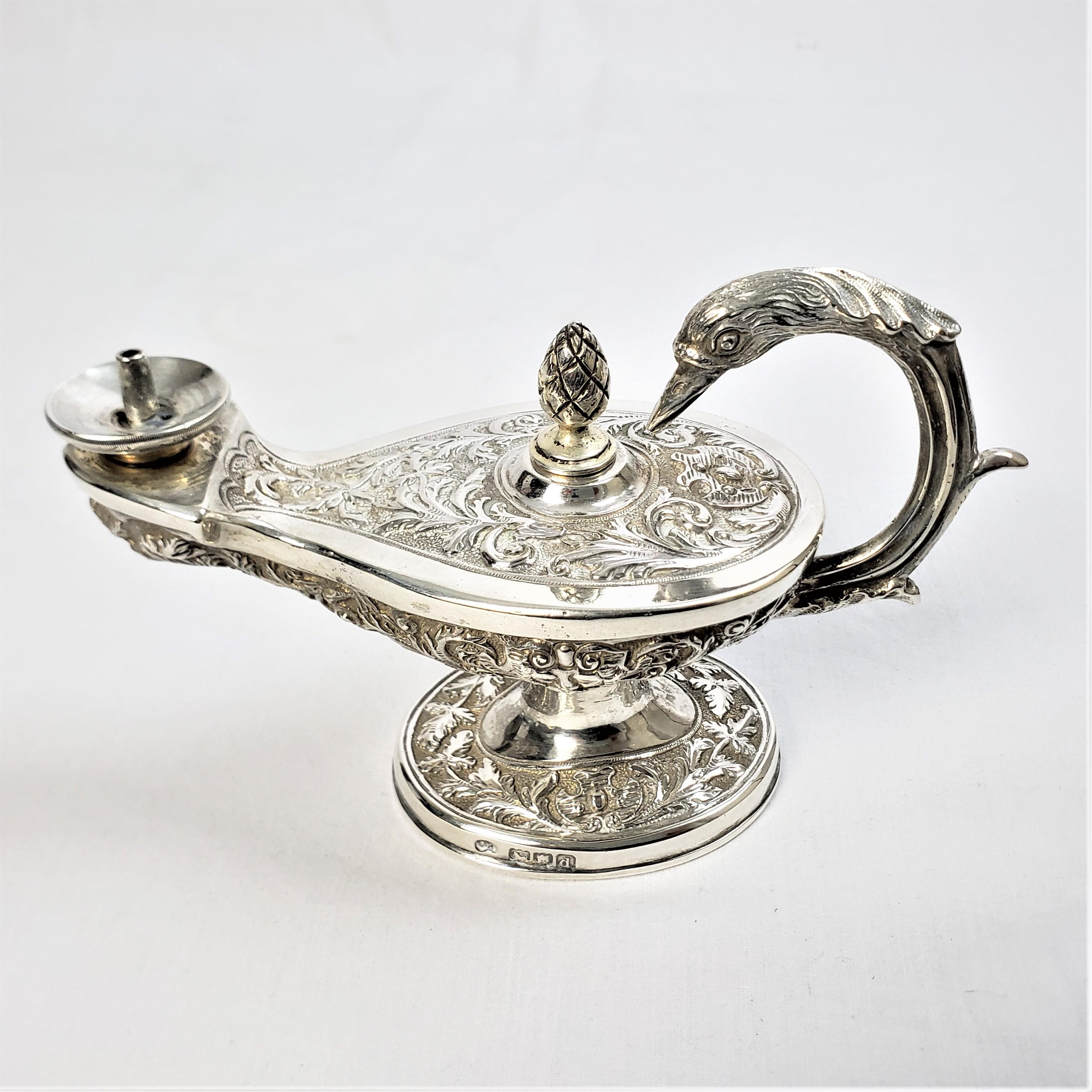 This antique figural table cigar lighter is hallmarked by an unknown maker, and originated from England, dating to 1815 and done in the period Georgian style. The lighter is composed of sterling silver with a weighted base, and metal wand and