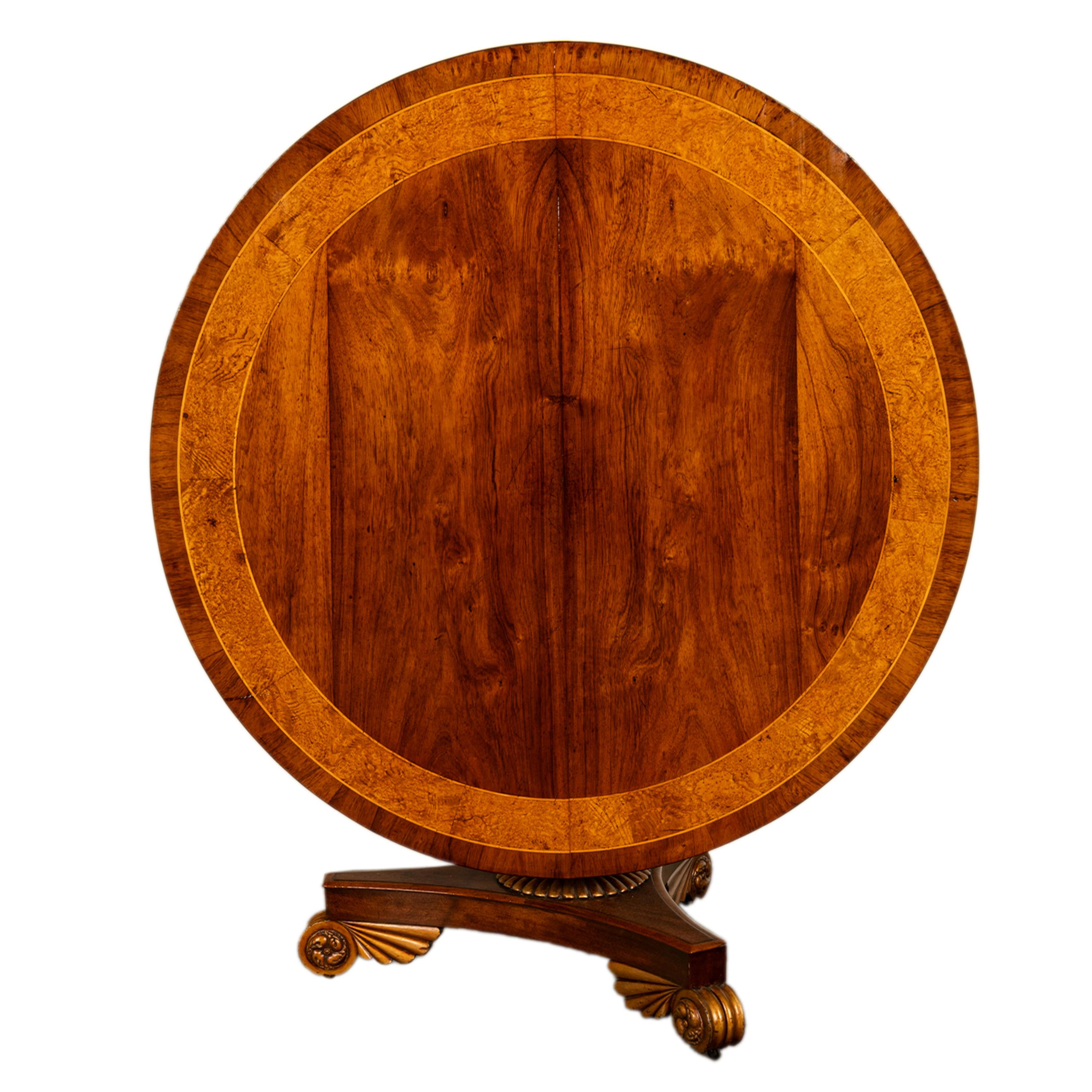 Table de déjeuner et de salle à manger en noyer et amboine, marquetée et dorée parcellaire, d'époque Regency géorgienne, vers 1820.
Le plateau circulaire basculant est en noyer figuré et incrusté de bois de satin et d'une bande d'incrustation en