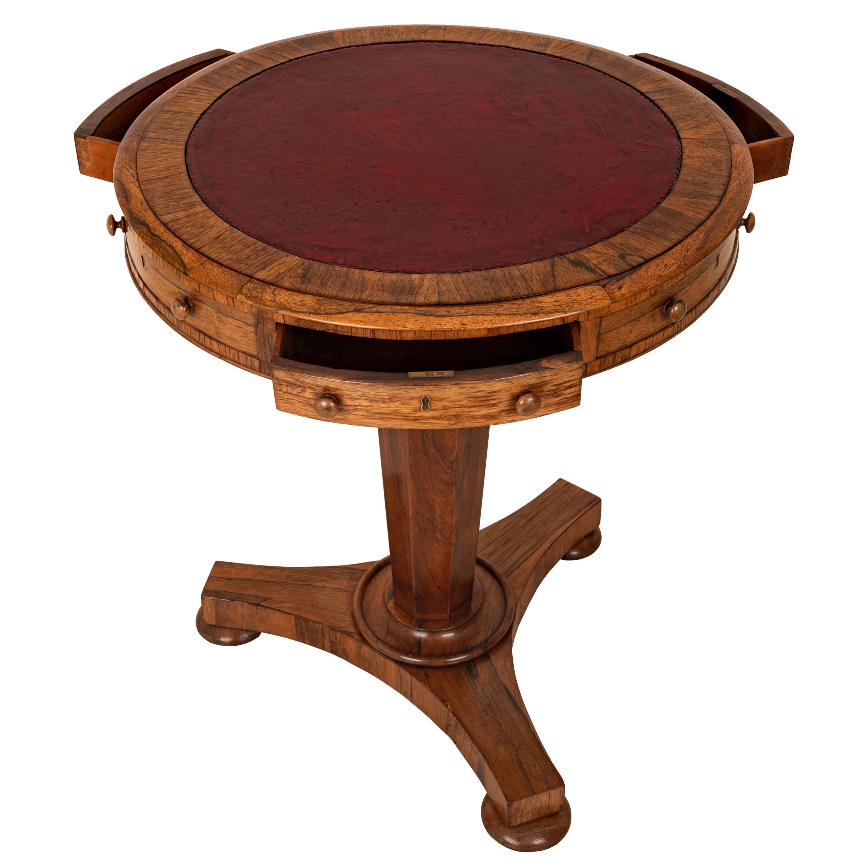 A very good antique Georgian Regency Brazilian rosewood pedestal drum table, circa 1825.
The rosewood banded top inset with the original gilt-tooled ox-blood red leather above a frieze with three mahogany-lined working & locking drawers and three