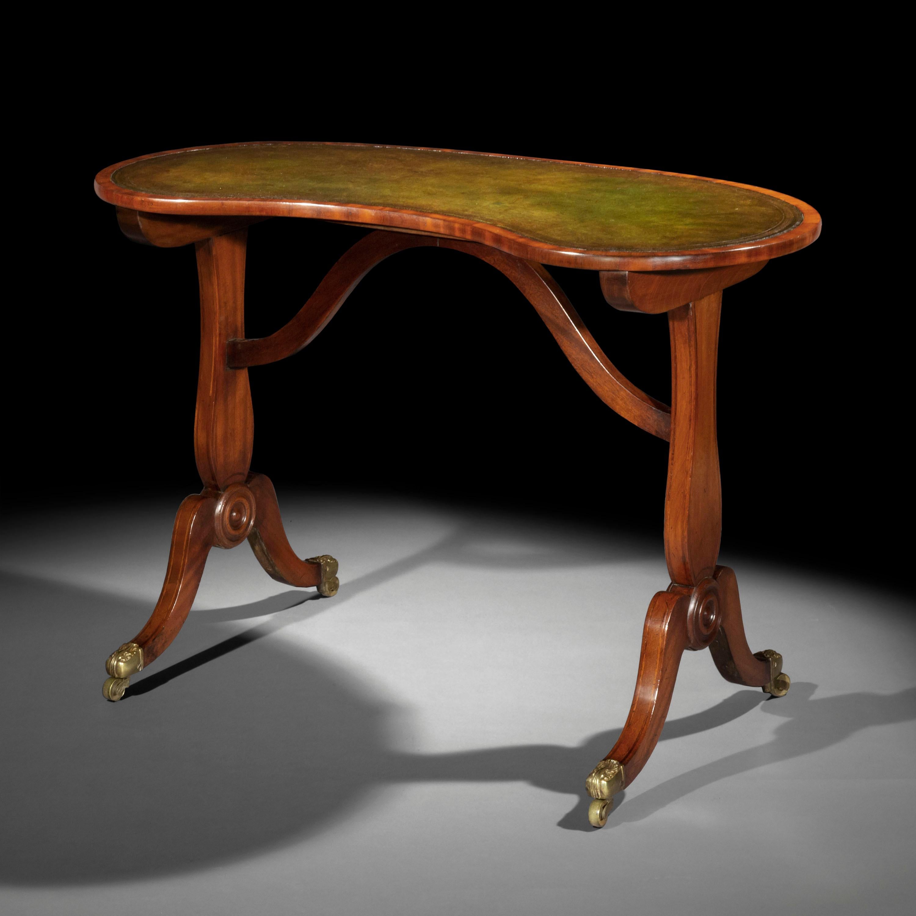 An unusual early 19th century writing table of 'kidney' shape, with patinated green leather-inset top.

English, circa 1810.

Elegantly understated, this table is useful and versatile with its tooled leather top and slender supports.

Two similar