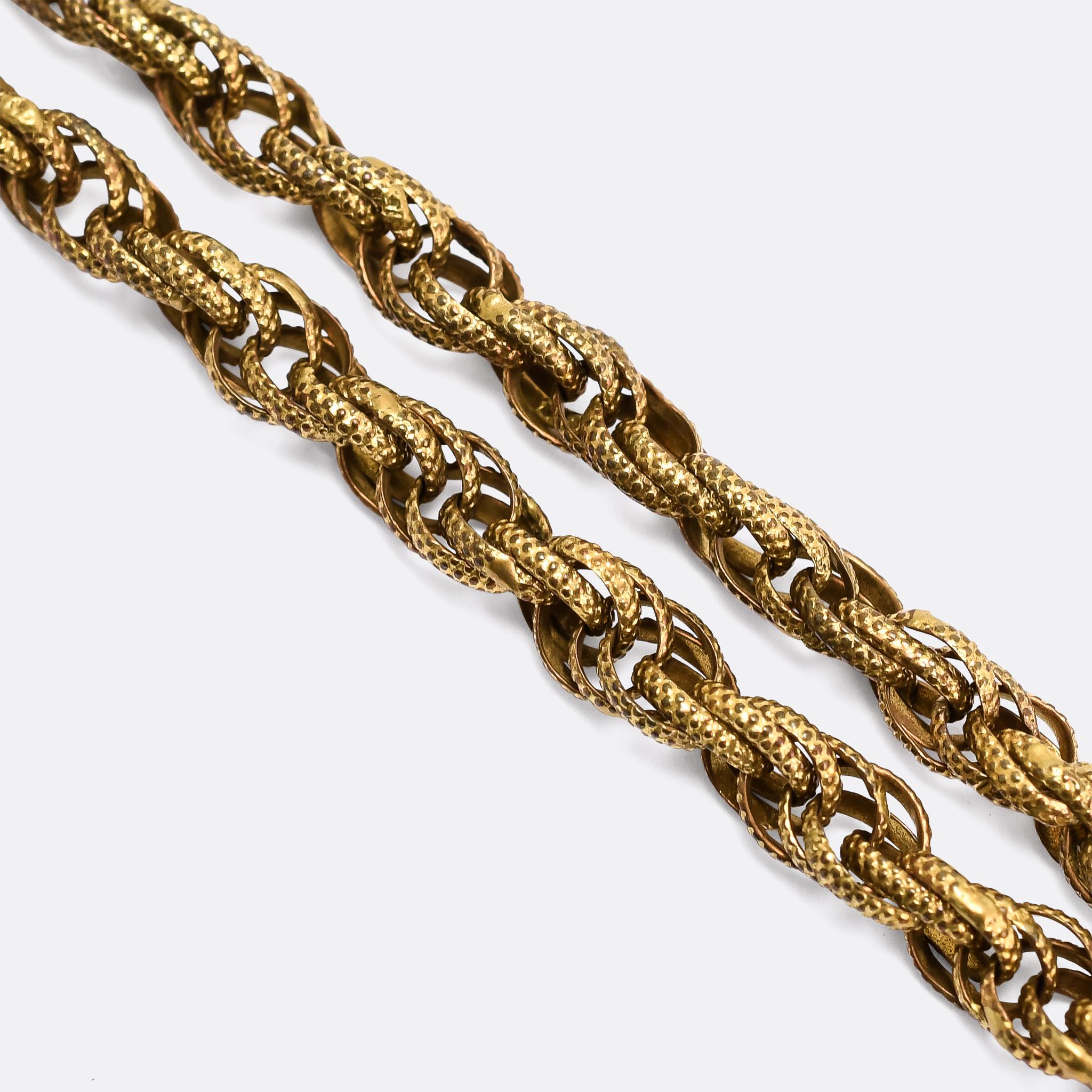 An exquisite Georgian Regency pinchbeck guard chain dating from the early 19th Century, circa 1810. It's beautifully made, with textured oval links that interlink to create a spiral effect, and an elaborate barrel clasp with cannetille embellishment