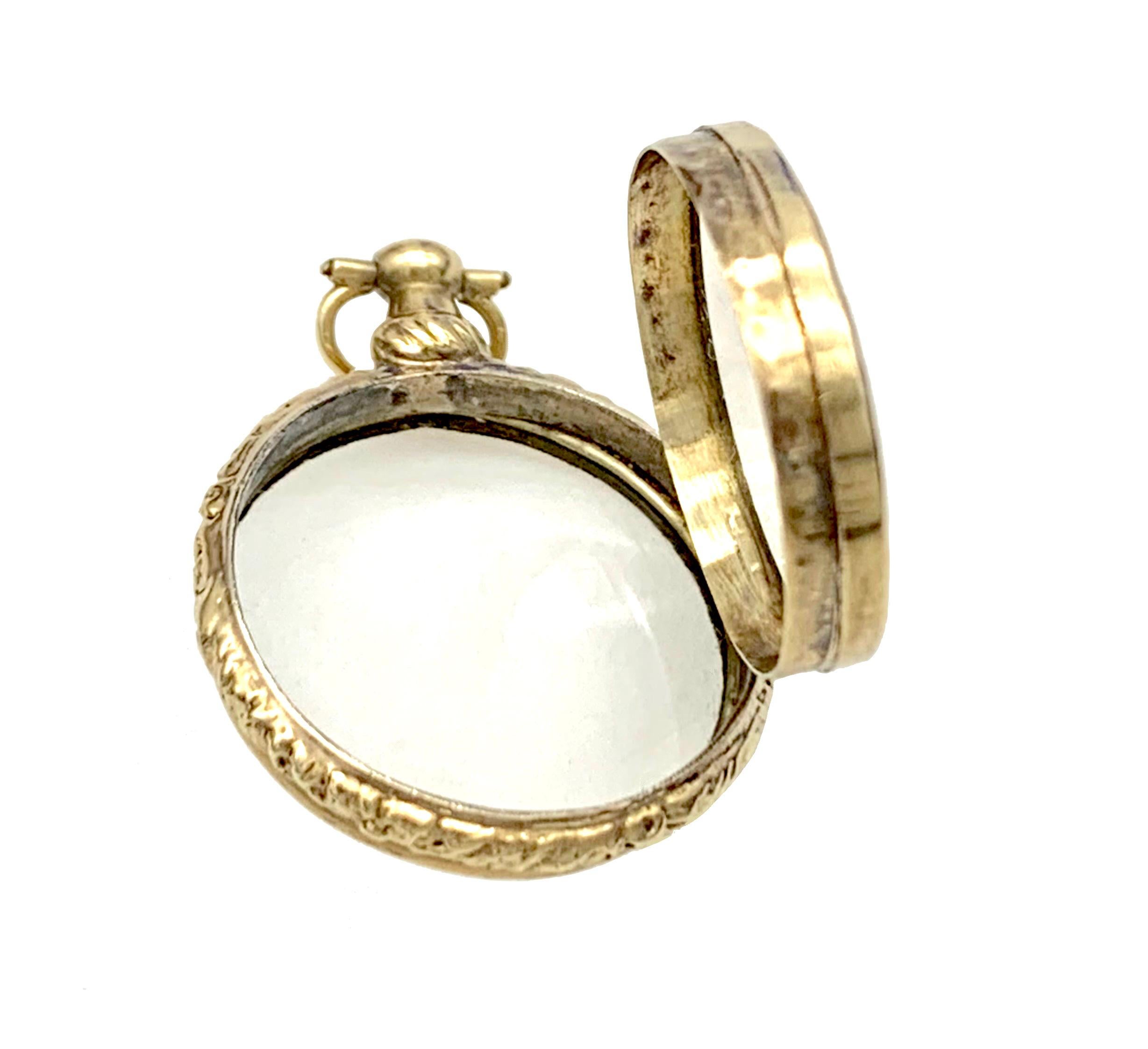 This elegant little georgian gold locket pendant was made around 1820. The 14 karat gold locked mount is finely chased all around with flowers and foliage. Each side of the locket is set with a domed rock crystal. The rock crystal has a slightly