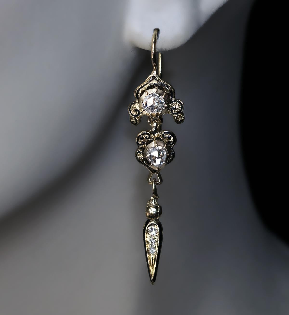 Circa 1830

These rare late Georgian era antique 18K gold pendant earrings are set with chunky old rose cut diamonds in closed back settings. The diamonds are accented by glossy black enamel.

Estimated total diamond weight 1.20 ct.

Total length