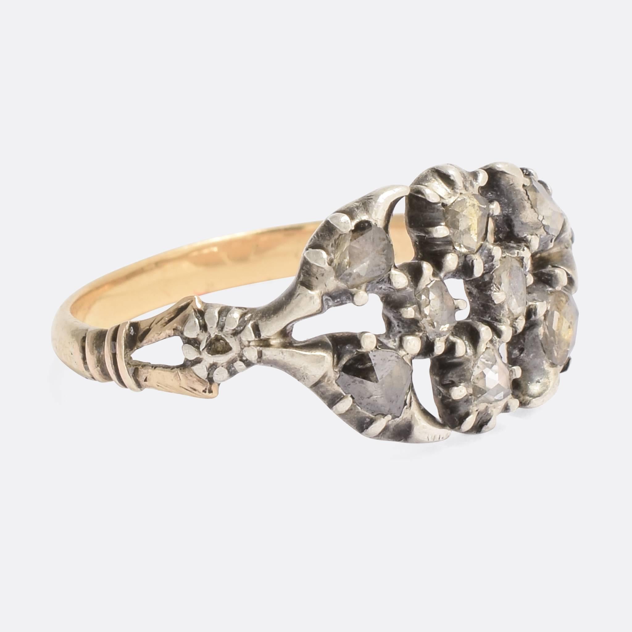 A beautiful antique cluster ring set with glistening rose cut diamonds. The piece dates to the early 19th Century, typically late Georgian in style, modelled in 15k gold and silver. The head is beautifully openworked with foliate motifs, while the