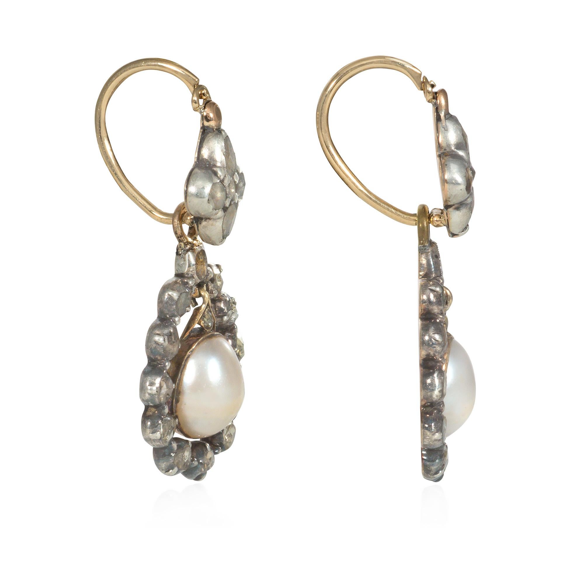 A pair of antique Georgian period diamond and pearl earrings, the pendants comprised of articulated half pearls in pear-shaped rose diamond surrounds suspended from quatrefoil rose diamond surmounts, in sterling silver and 18k gold.  Approximately 1