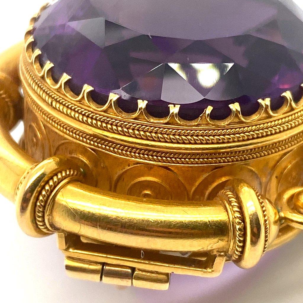 This antique Georgian (1714 to 1837) 20k gold brooch features an approximately 51.5ct round brilliant amethyst - at the time considered a cardinal gemstone alongside diamonds, sapphires, rubies, and emeralds - hand crafted in the high detail and