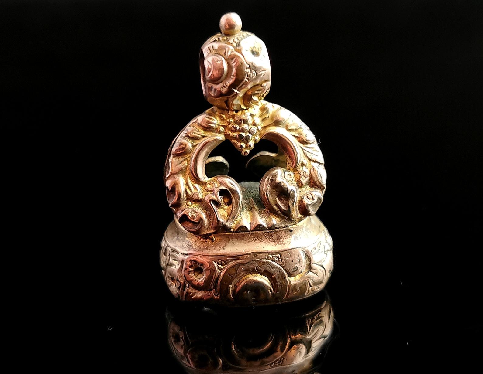 A beautiful antique, late Georgian 9ct gold plated and carved quartz crystal seal fob.

It is a very decorative seal with an elaborate chased and engraved style, scrolling arches and a bunch of grapes above the centre.

The seal fob is made from