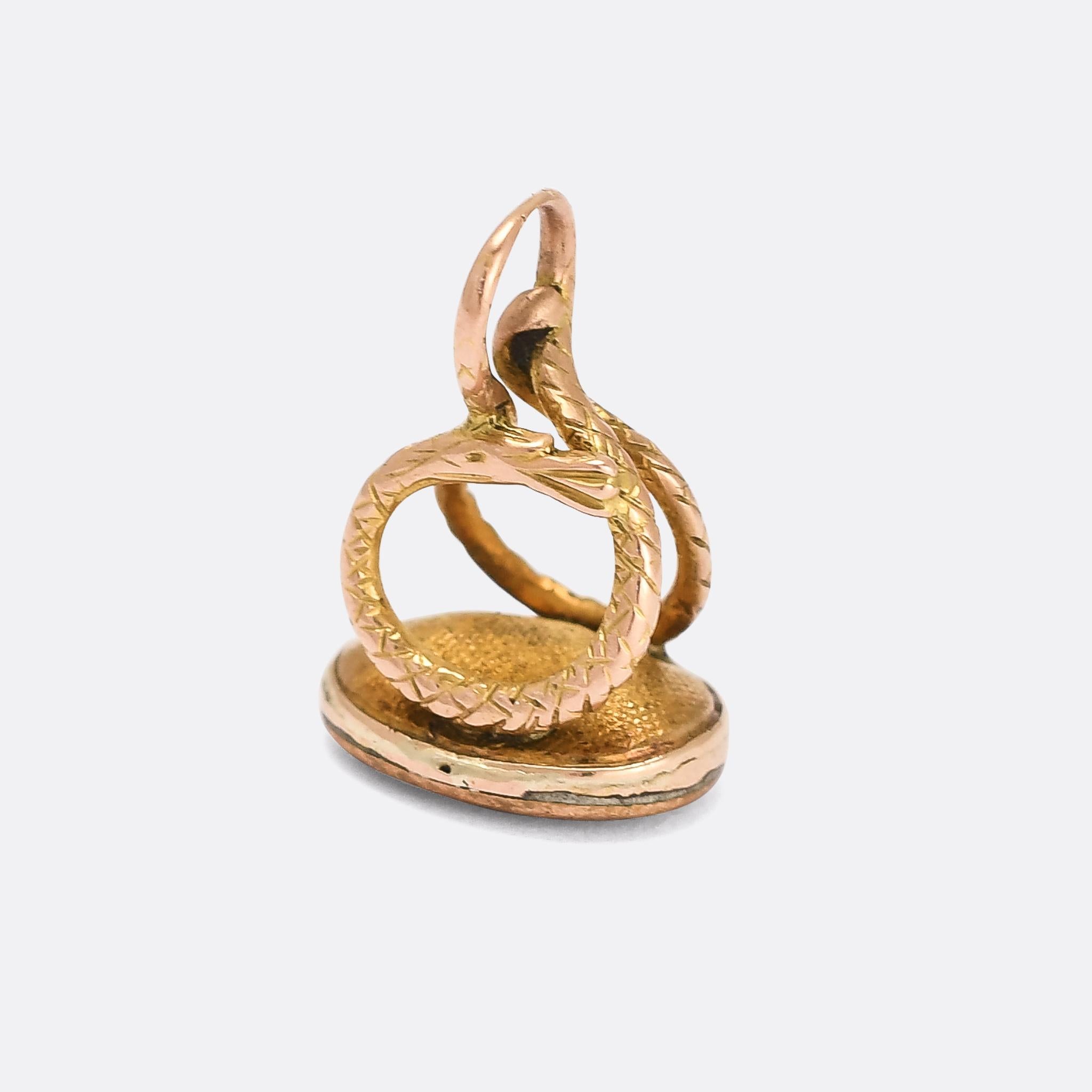 A cool Georgian seal fob dating from the early 19th Century, circa 1810. The body of the fob is a coiled snake, complete with cross-hatched scales, and it's set with an oval chalcedony stone in the base. These fobs were originally worn on the end of