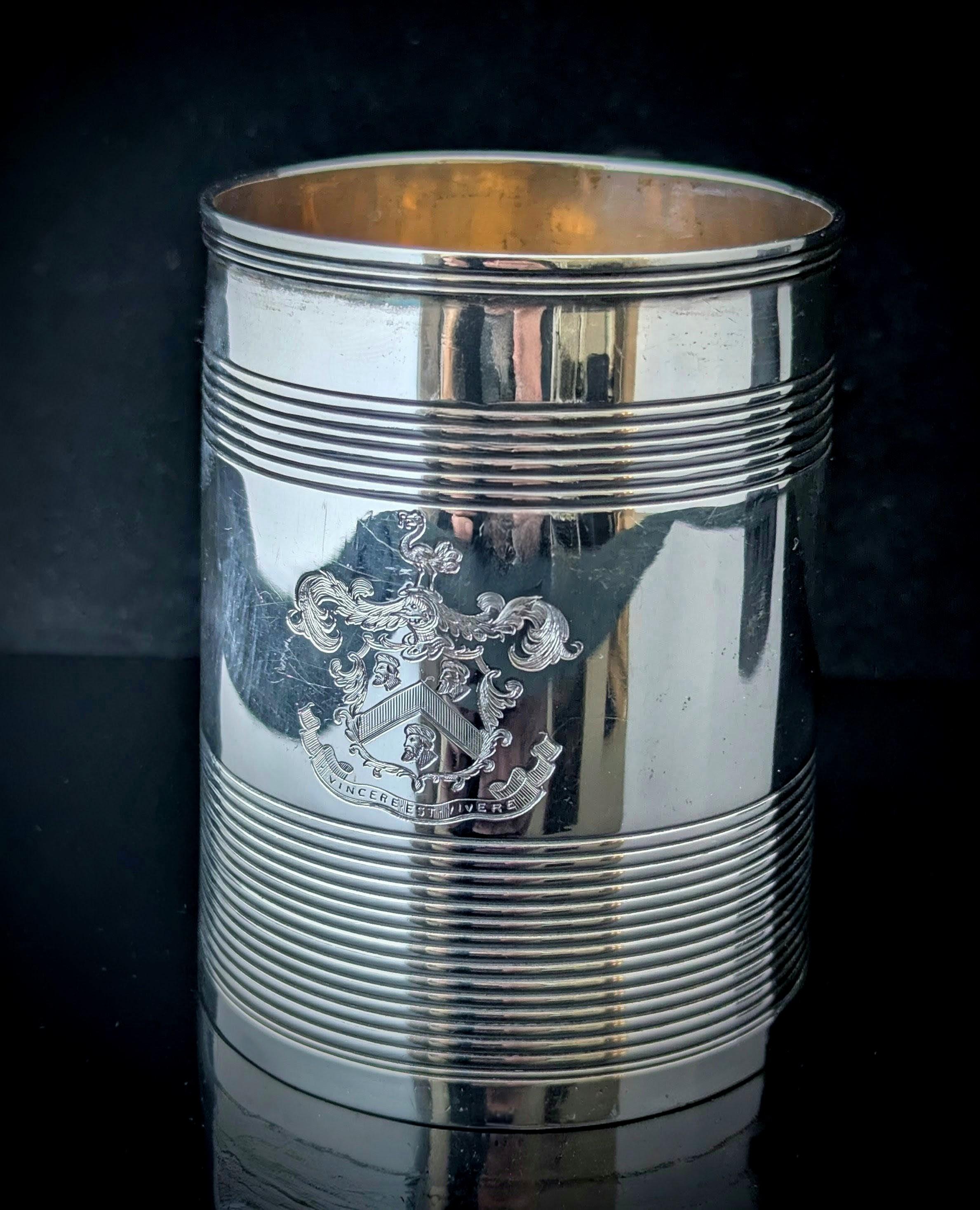 Una deliziosa tazza o boccale in argento sterling di epoca georgiana.

La parte superiore e quella inferiore presentano un disegno inciso, mentre la parte centrale è liscia. Sul davanti è inciso uno stemma araldico scritto in latino con tre uomini,