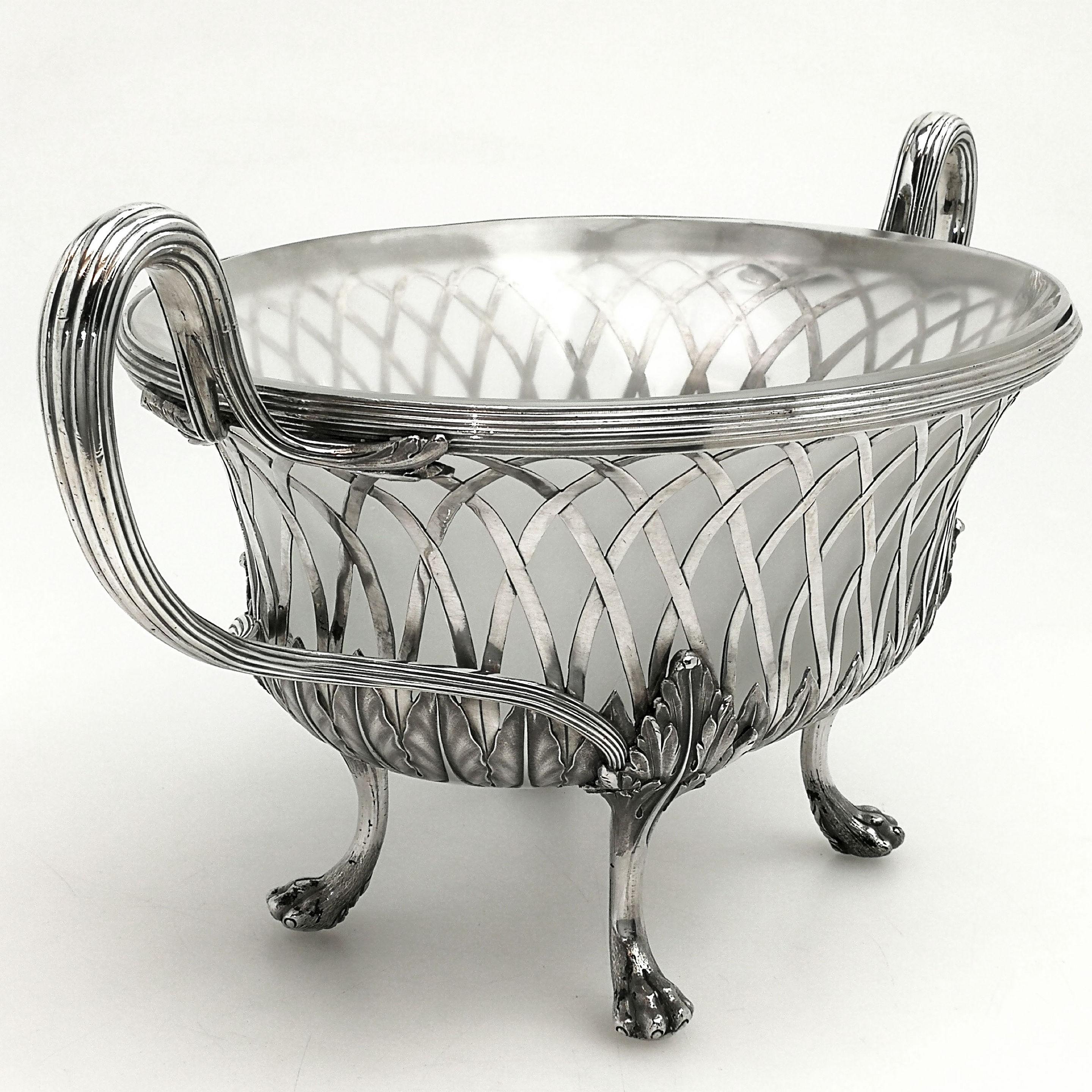 A rare George III Antique sterling Silver  Basket with a frosted white glass liner. The Georgian dessert serving Basket stands on four claw feet with acanthus leaf mounts. The base of the basket has an applied leaf border. The glass liner is of