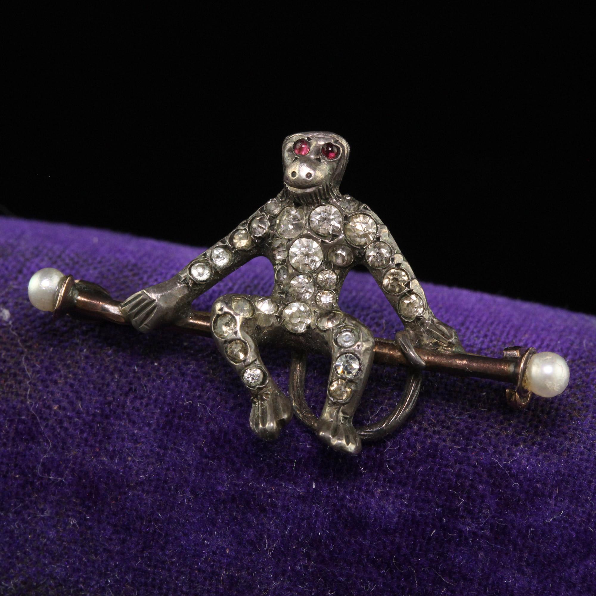 Beautiful Antique Georgian Silver Old Cut Paste and Pearl Monkey Pin. This gorgeous Georgian pin is crafted in silver. This pin features a monkey playfully sitting on a branch and has old cut diamonds set throughout its body. The branch has natural