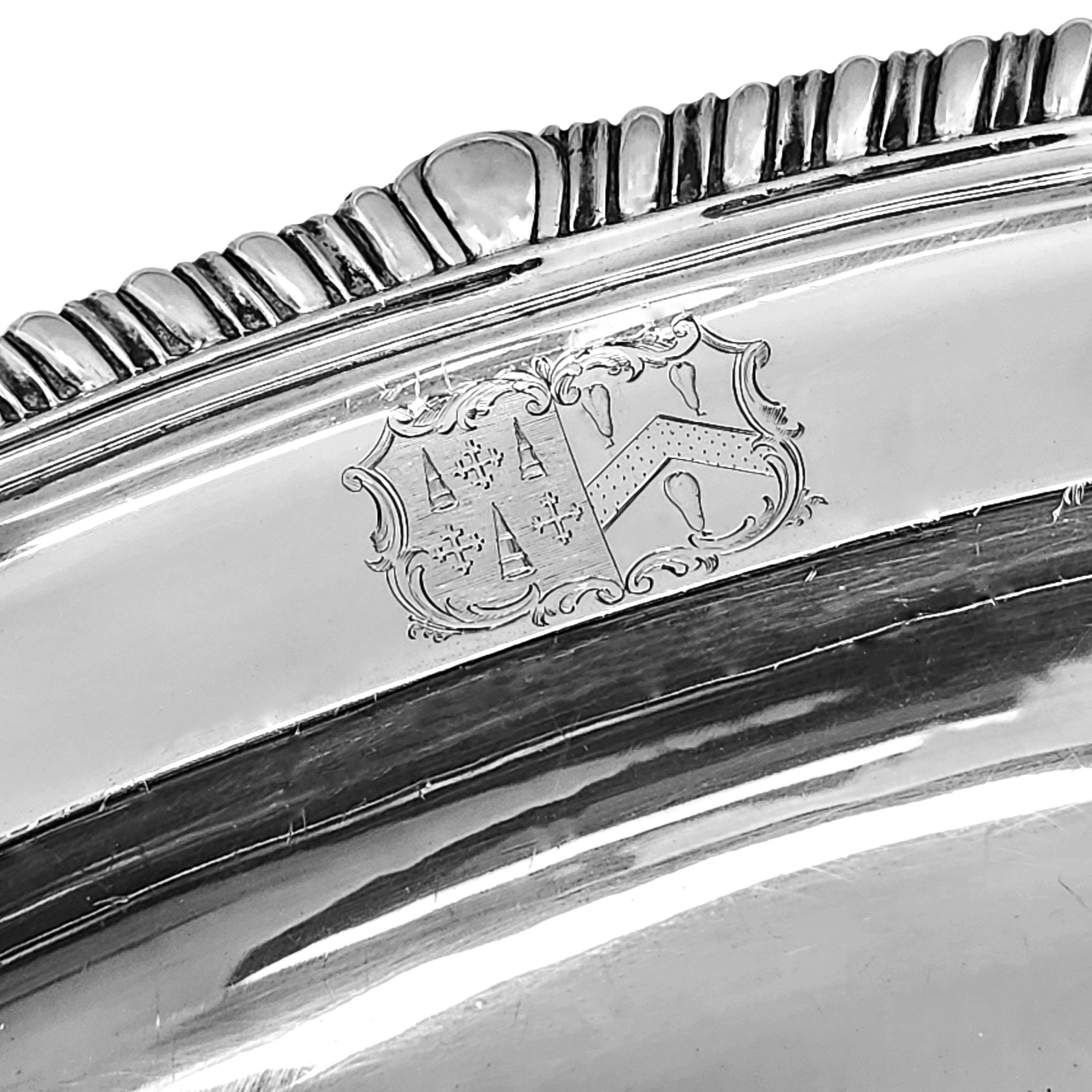 An impressive Antique George III Sterling Silver Meat Serving platter with a classic shaped Gadroon border and a small crest engraved on the rim.

Made in London, England in 1809 by William Stroud

Approx. Weight - 2800g / 90oz
Approx. Length - 56cm