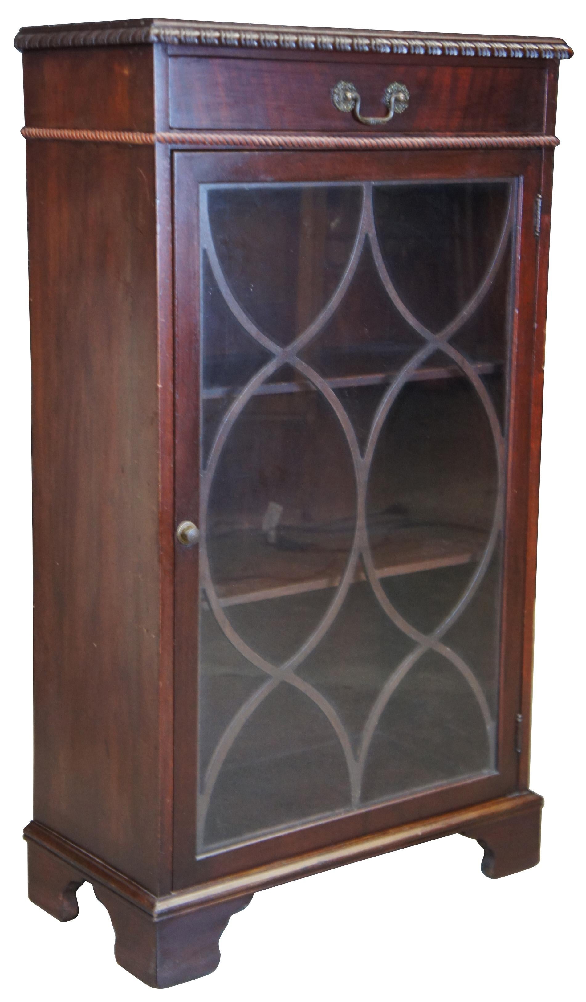 Georgian inspired cabinet by Sligh Lowry Furniture Company, circa 1950s. A diminutive cabinet made from mahogany with one drawer and lower cabinet for display. Features three fixed shelves and fretwork behind glass. Cabinet is supported by bracket