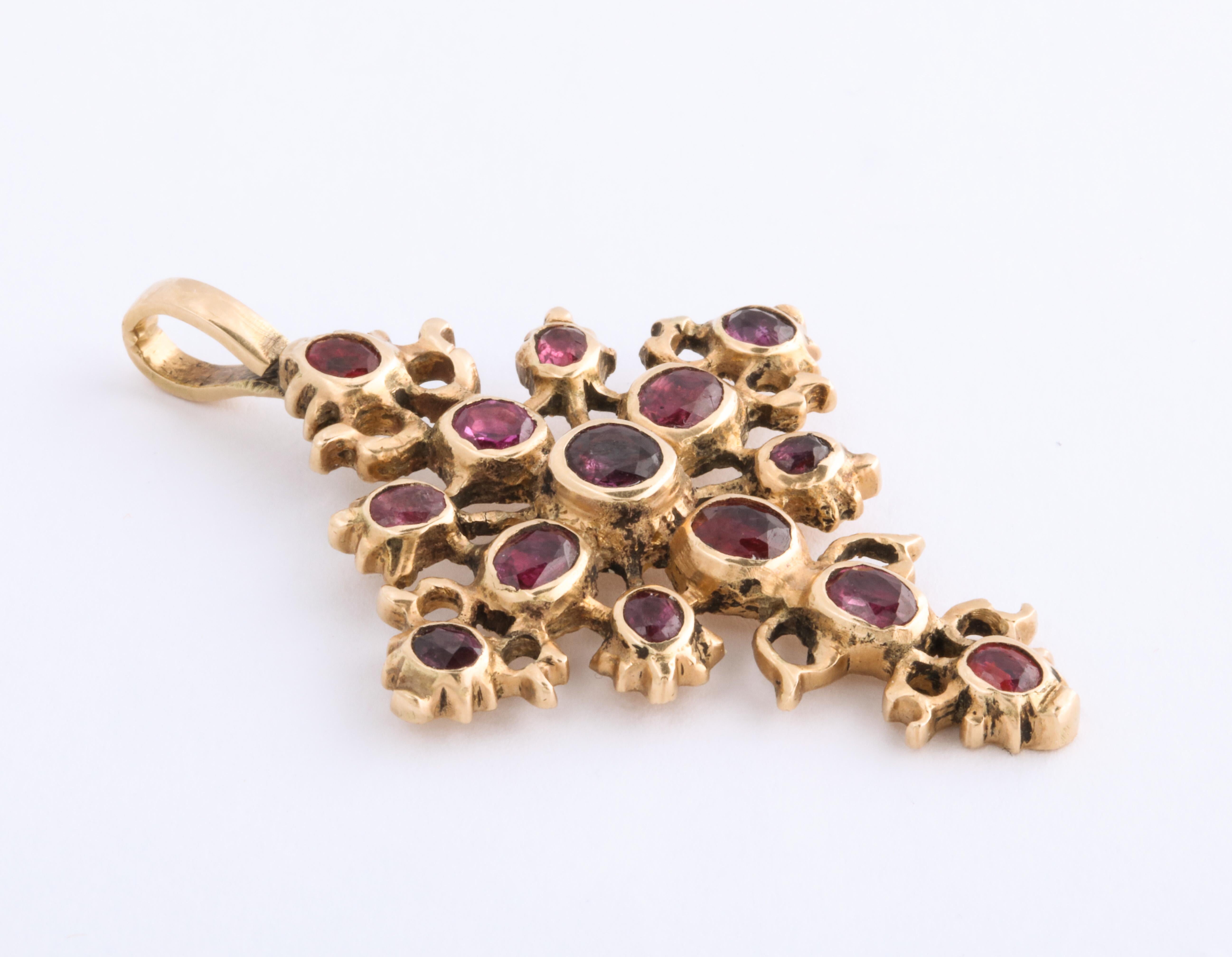   A rare example of Spanish jewelry, this magnificent ruby 18 Kt gold cross, with substantial and strong bezels, is set with fourteen natural, oval rubies of fine quality ranging in size from 10 points to 20-25 points. The total weight of the stones
