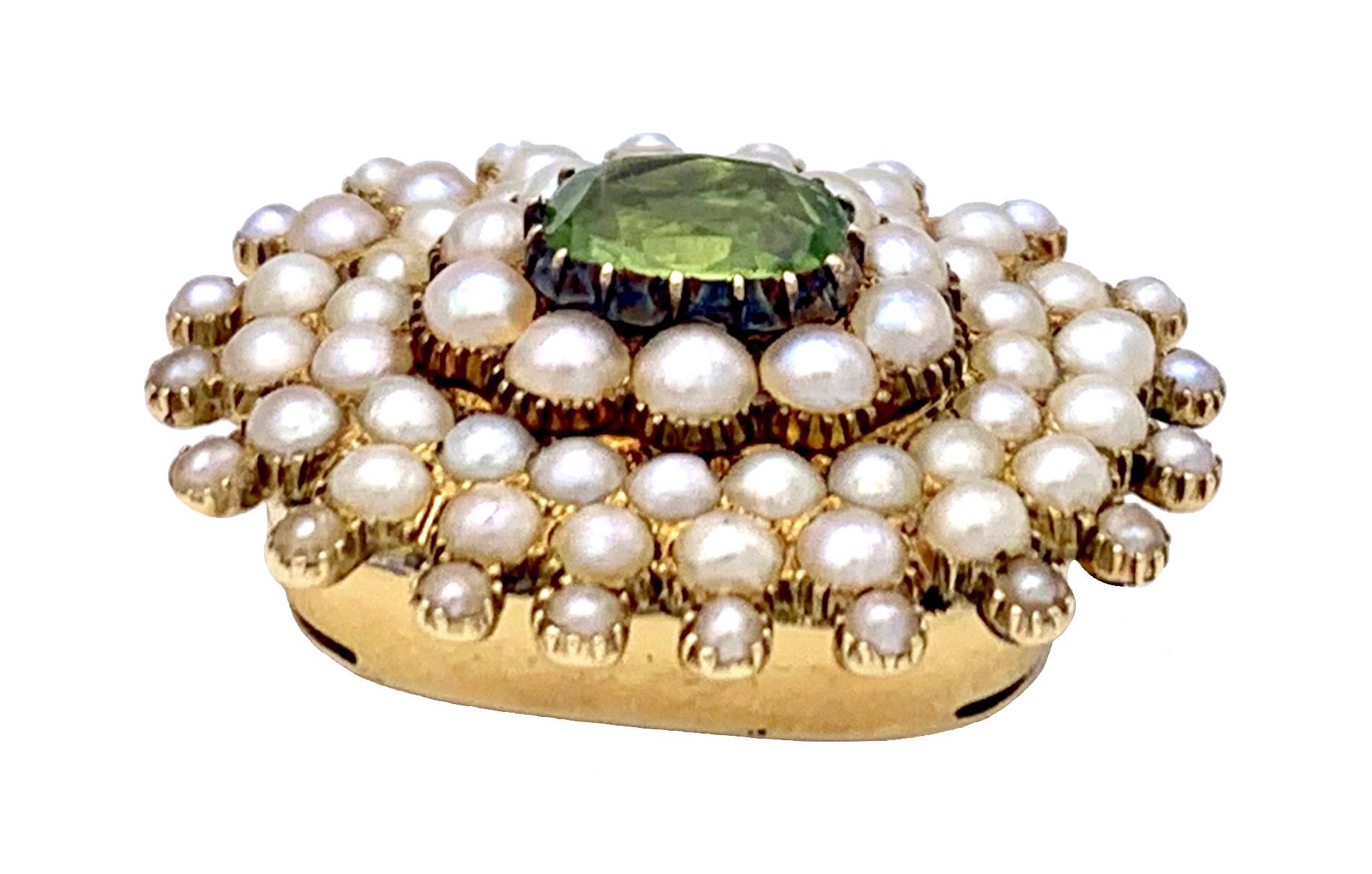 This precious clasp designed as a starburst was intended for a bracelet or a necklace, most likely to be worn with pearls.  The oval fasetted peridot has been set in a silver setting with golden claws and then mounted onto the golden clasp together